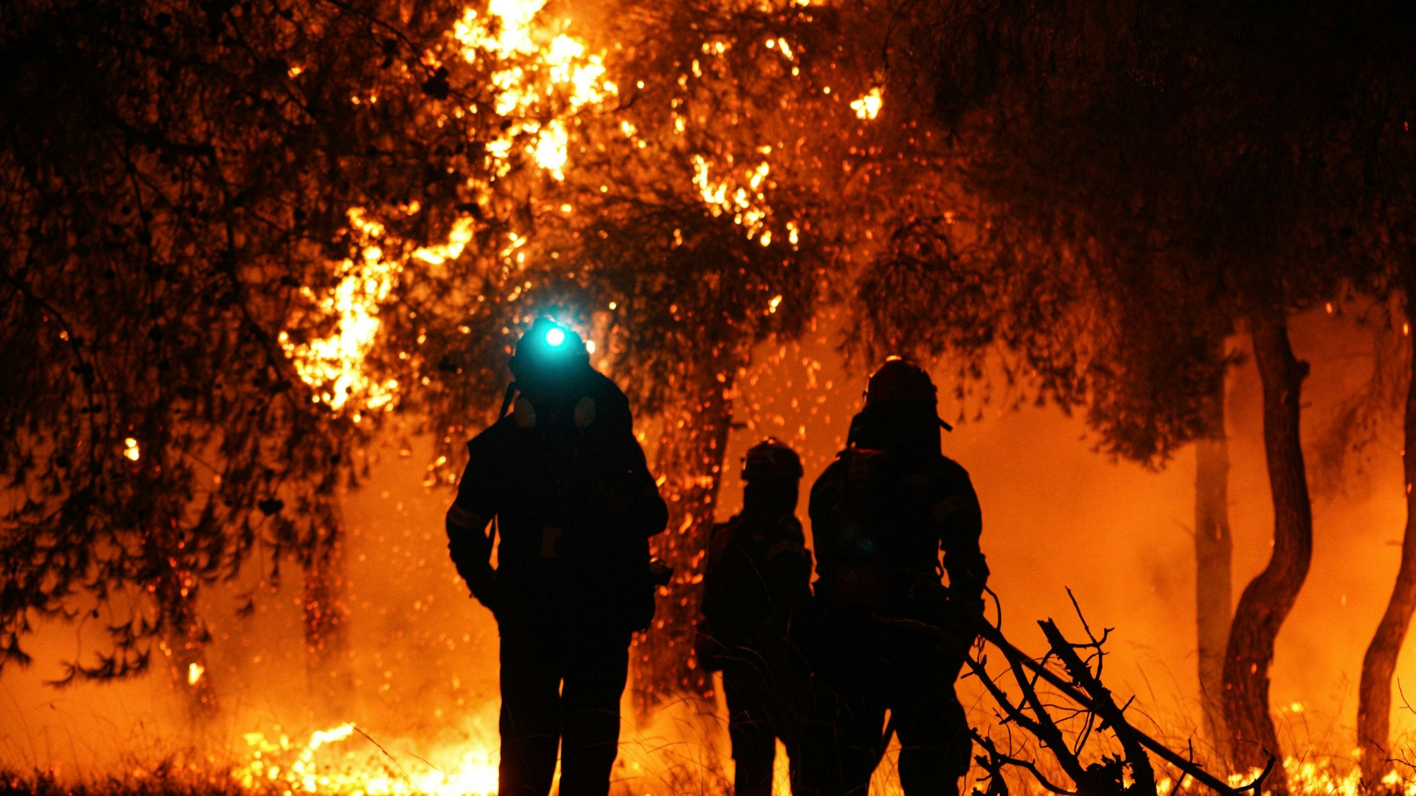Feuerwehrleute löschen die Flammen während eines Waldbrandes in Griechenland.
