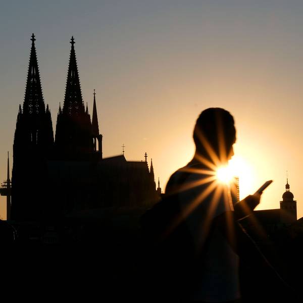 Menschen genießen im Sonnenuntergang am Rheinboulevard vor dem Dom die Abendstimmung. (Archivbild)