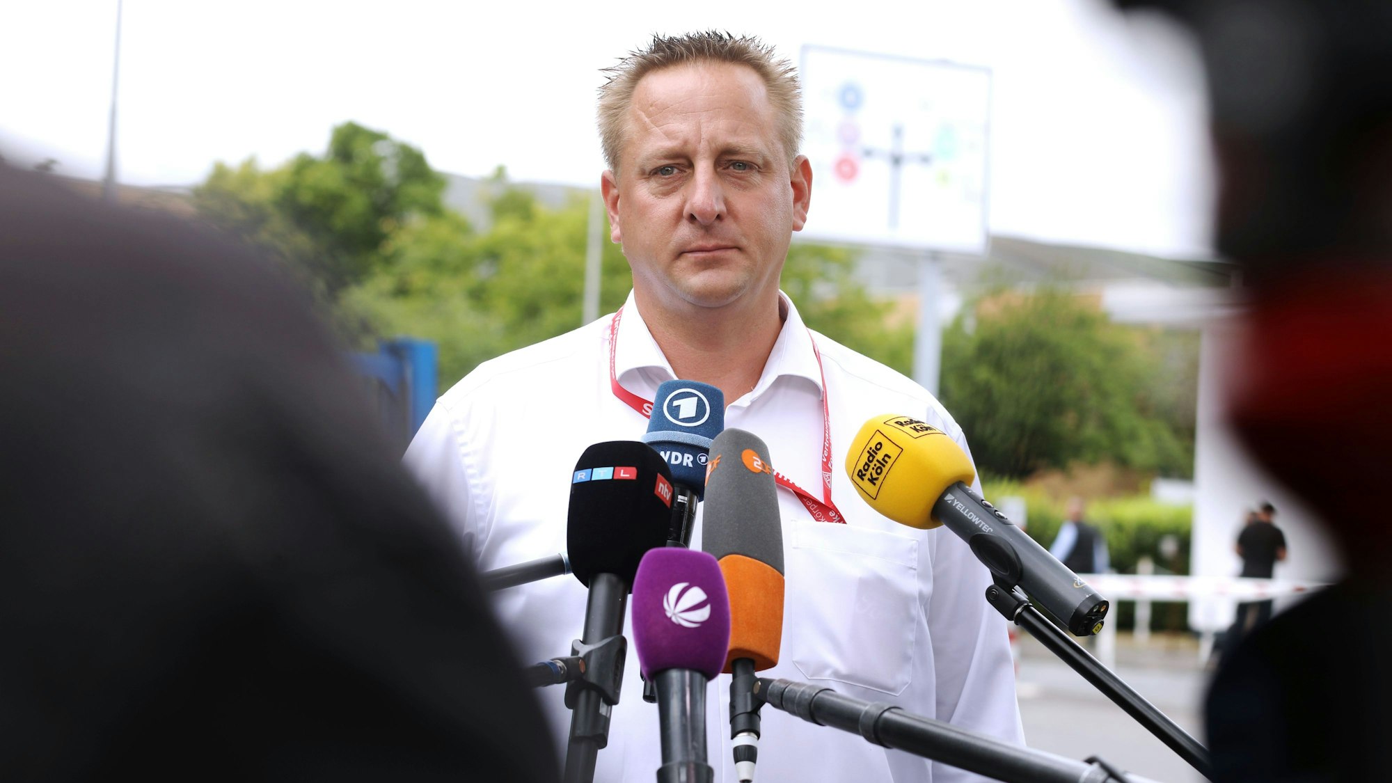 11.07.2025, Köln: Benjamin Gruschka Betriebsrat von Ford erklärt vor Tor 24 bei Ford die Verhandlungsergebnisse der Presse. Bei Ford wird die Entscheidung der US-Mutter verkündet, inwieweit die Belegschaft von 11.500 Menschen in Köln im Falle einer Insolvenz trotzdem mit Abfindungen abgesichert sind. Foto: Arton Krasniqi