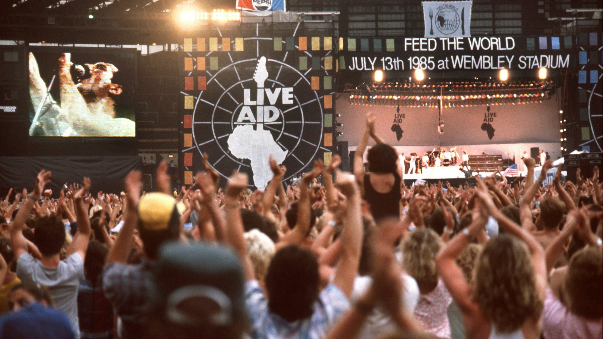 13.07.1985, Großbritannien, London: Die Fans jubeln während des Auftritts von "Queen"-Sänger Freddie Mercury.