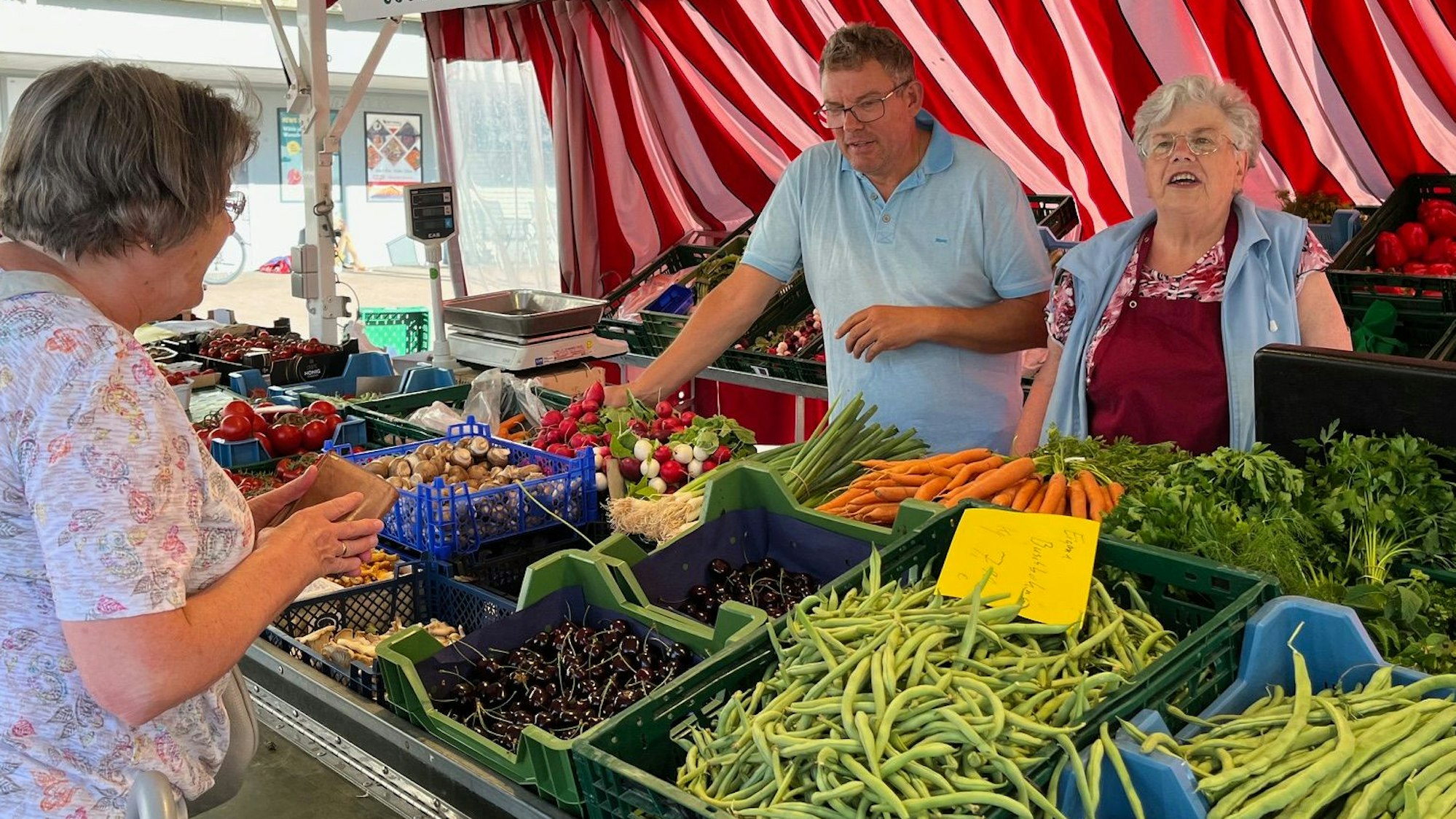 Zu sehen ist der Gemüsestand von Thomas Zimmermann, eine weitere Frau bedient eine Kundin.