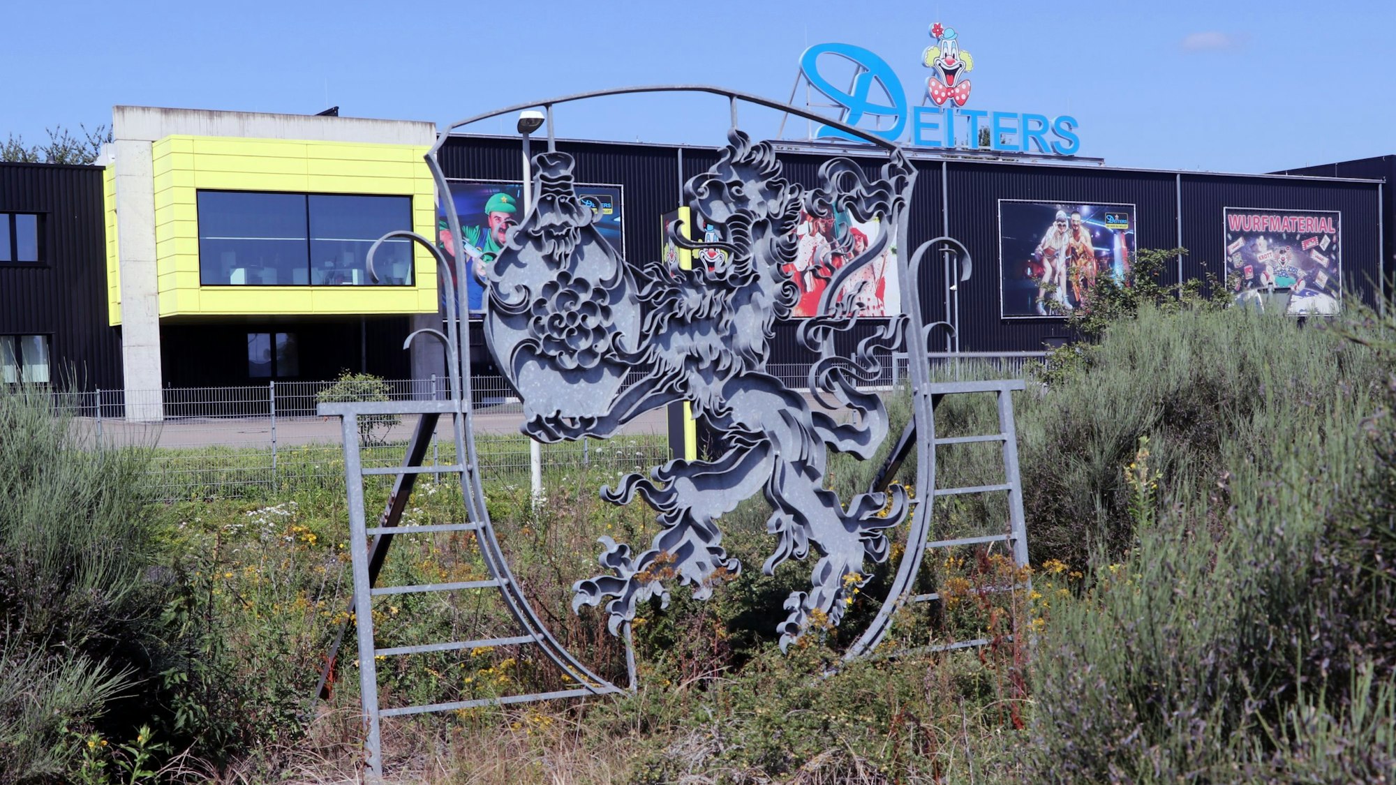 Auf dem Bild sind Gebäude von Hallen und ein Stadtwappen zu sehen.