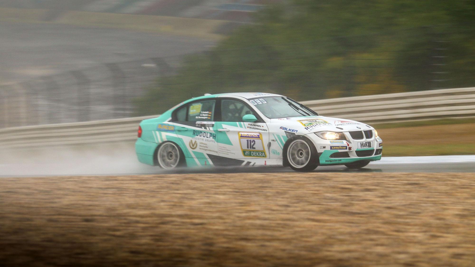Ein BMW 325i Rennauto fährt über eine Strecke.