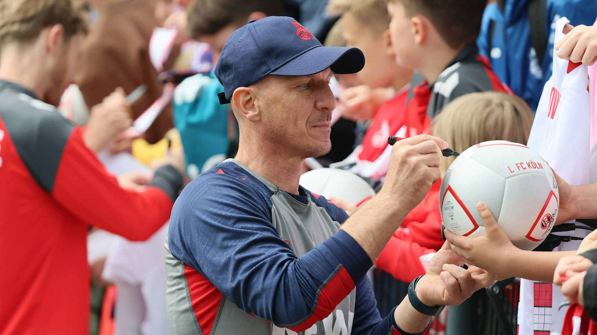 Gerhard Struber signiert bei einer Autogramm-Runde einen Ball.