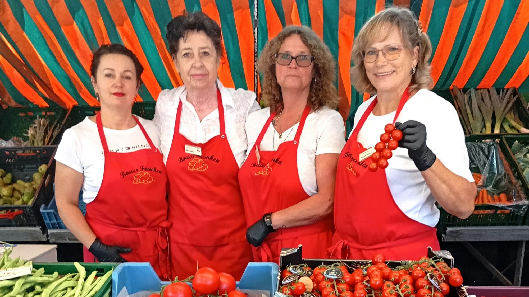 Das Foto zeigt Frauen hinter einem Gemüsestand.