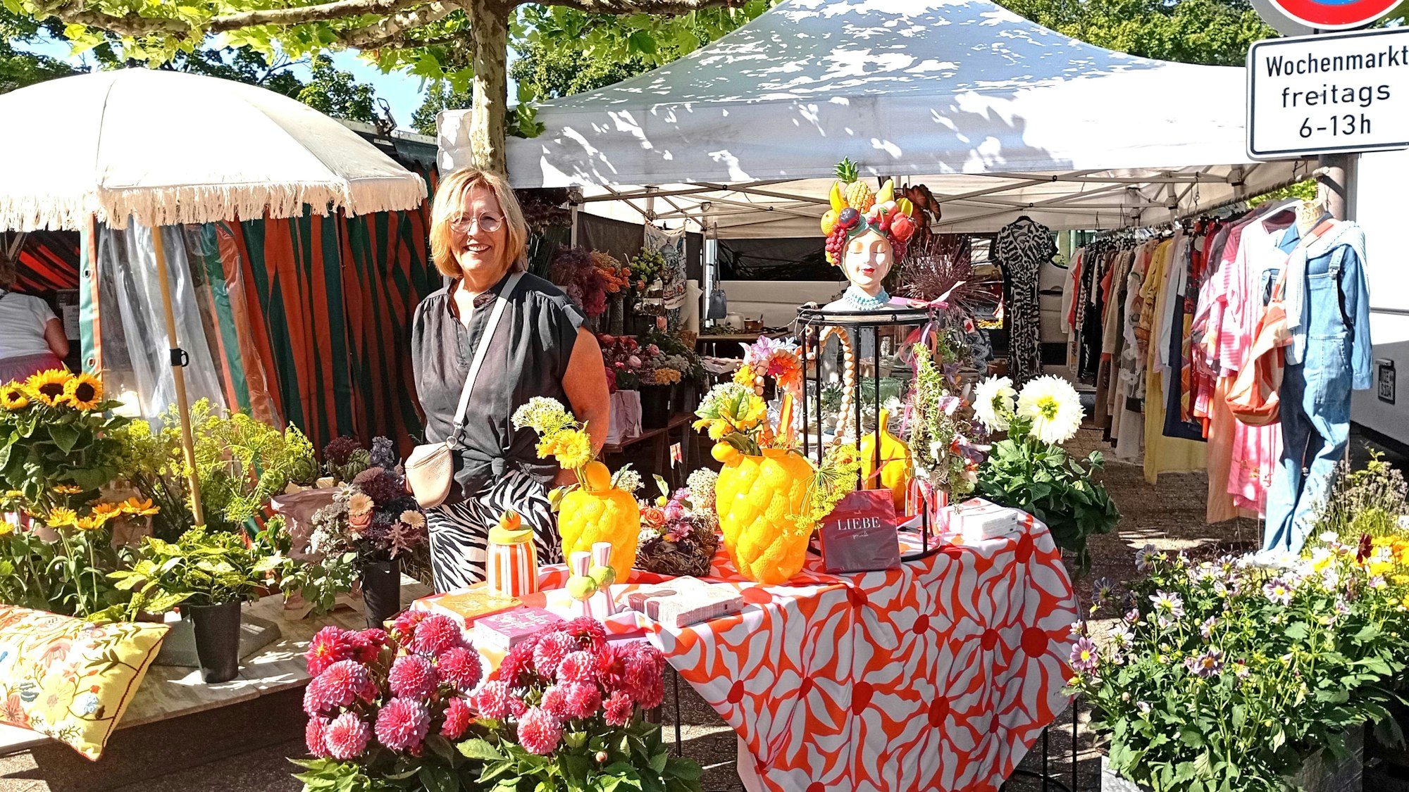 Das Foto zeigt eine Frau an einem Blumenstand.