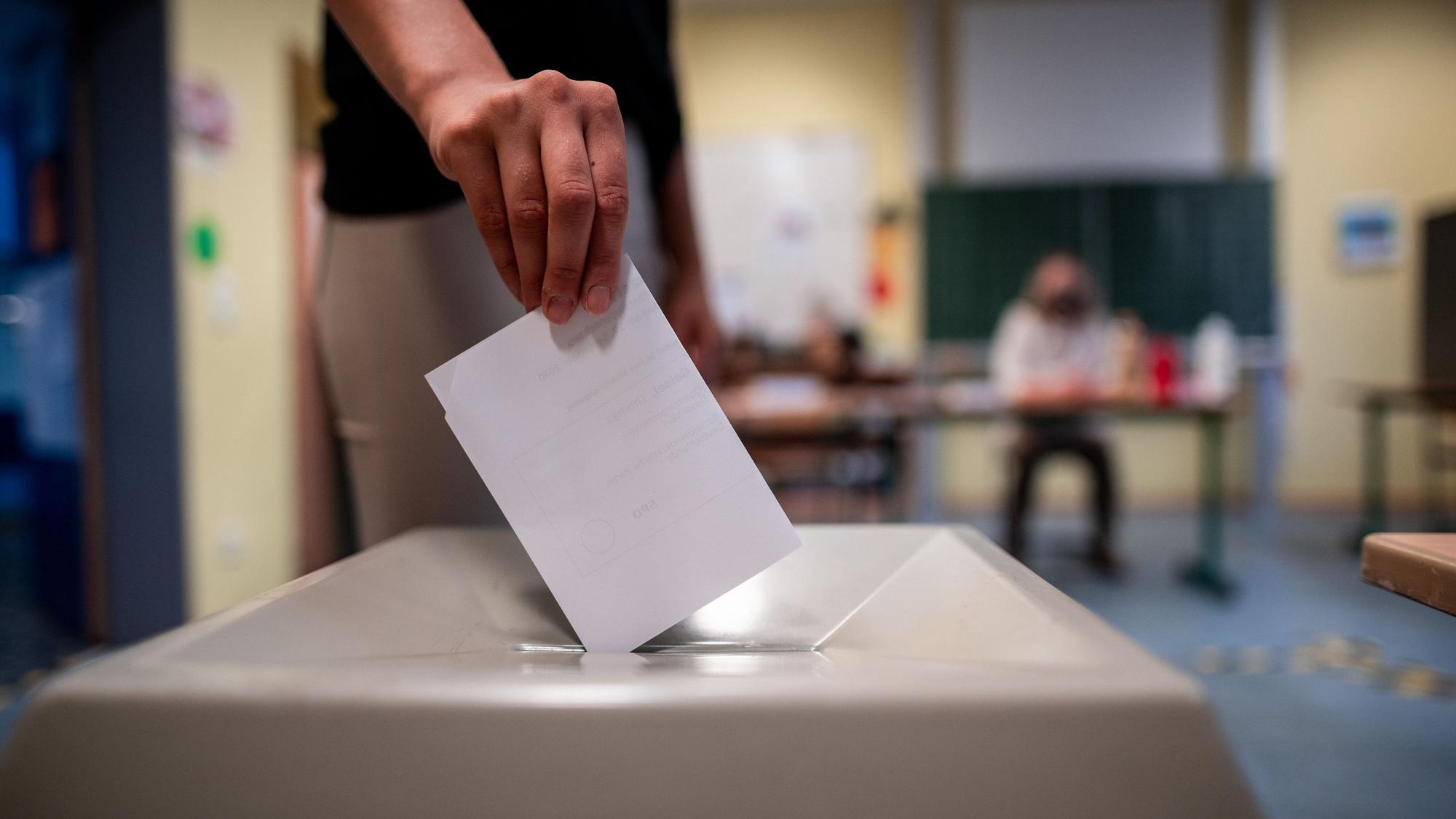Archiv: Eine Frau wirft einen Wahlzettel in eine Wahlurne in der Marien-Schule in Düsseldorf.