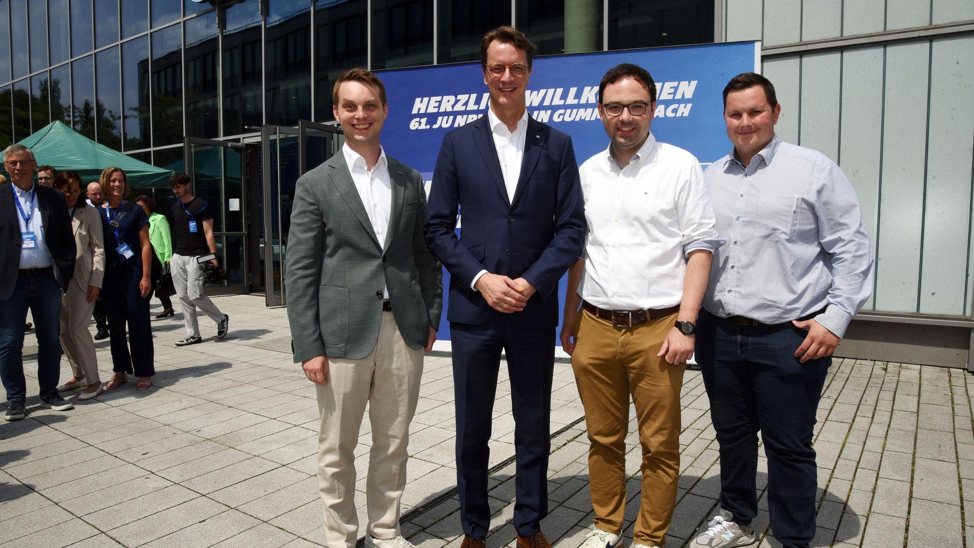 Vier Männer vor einer Veranstaltungshalle.