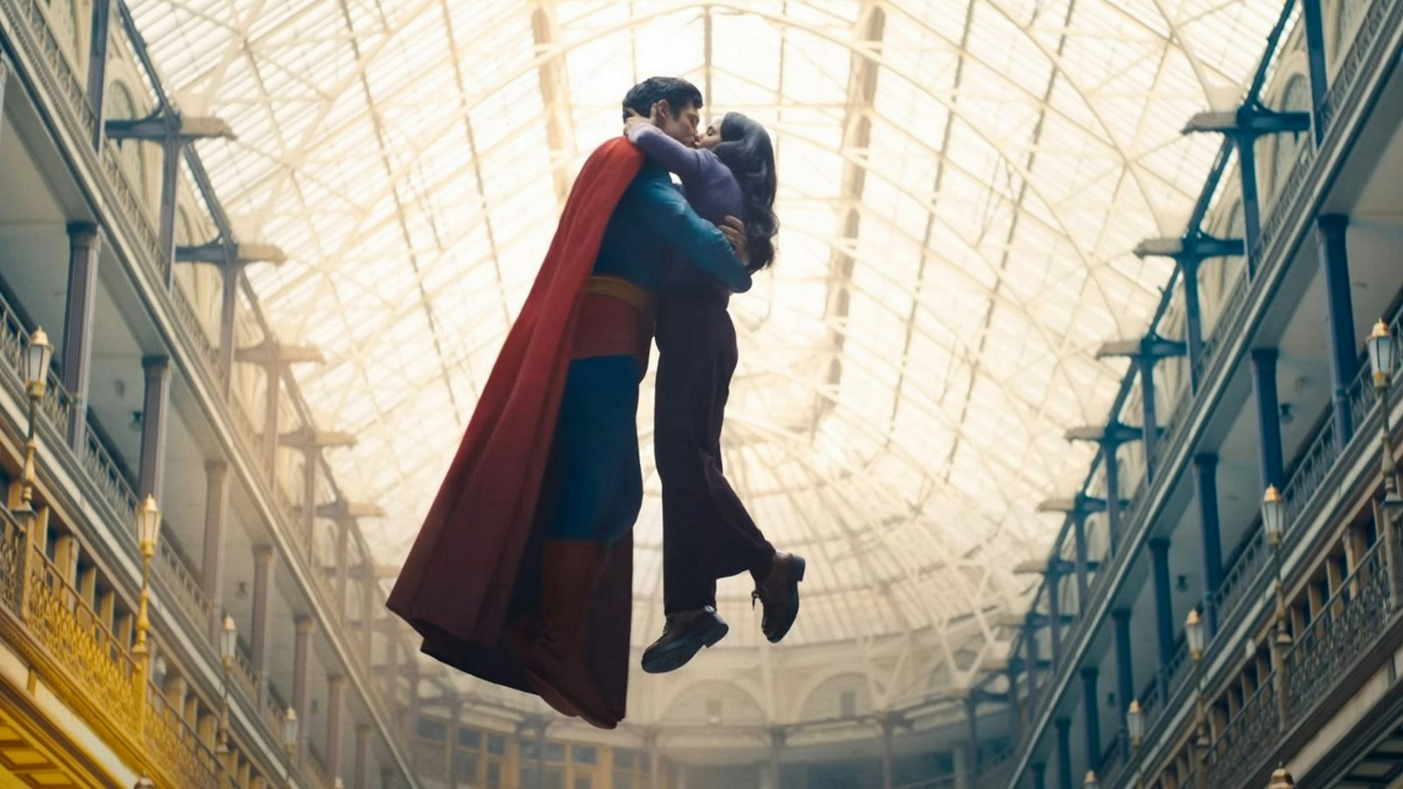 Superman und Lois Lane küssen sich in der Luft schwebend unter dem Glasdach einer Passage.