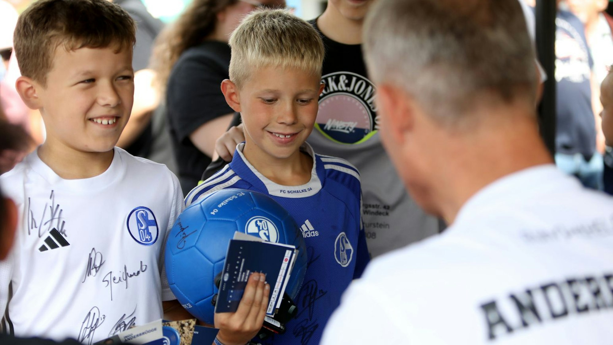 Junge Schalke-Fans warten auf ein Autogramm von Ingo Anderbrügge.