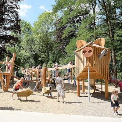 Kinder spielen auf dem neuen Spielplatz im Kurpark in Gemünd. Die Spielgeräte sind aus Holz gestaltet.