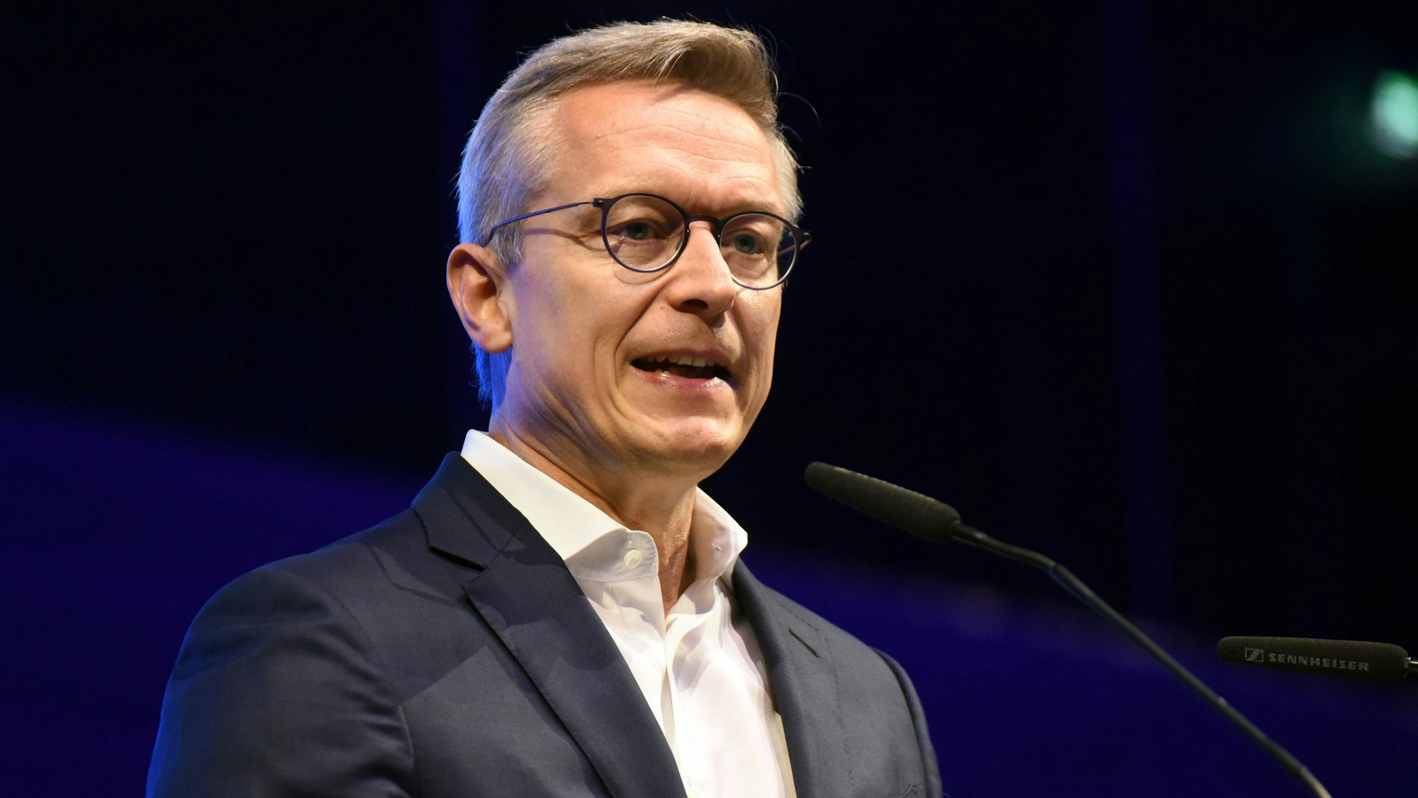 Ein Mann mit Brille am Mikrofon.