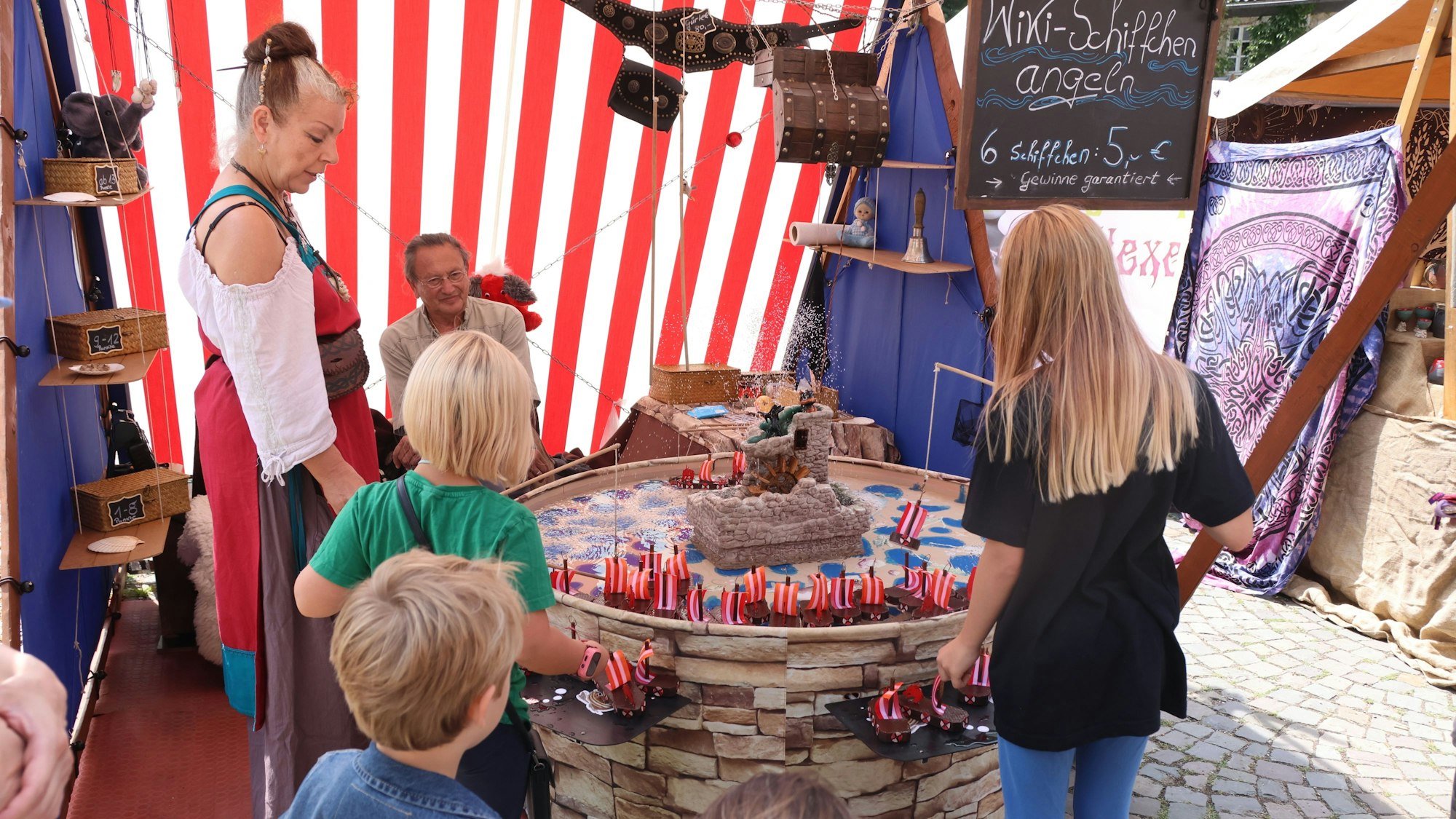 Eine Frau sieht Kindern zu beim Wikingerschiff-Angeln.