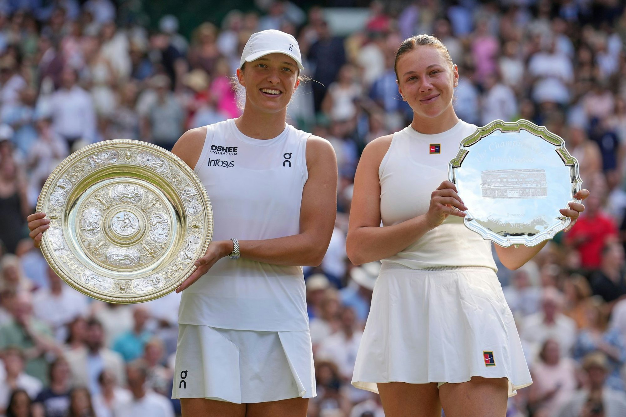Swiatek und Anisimova zeigen ihre Trophäen.
