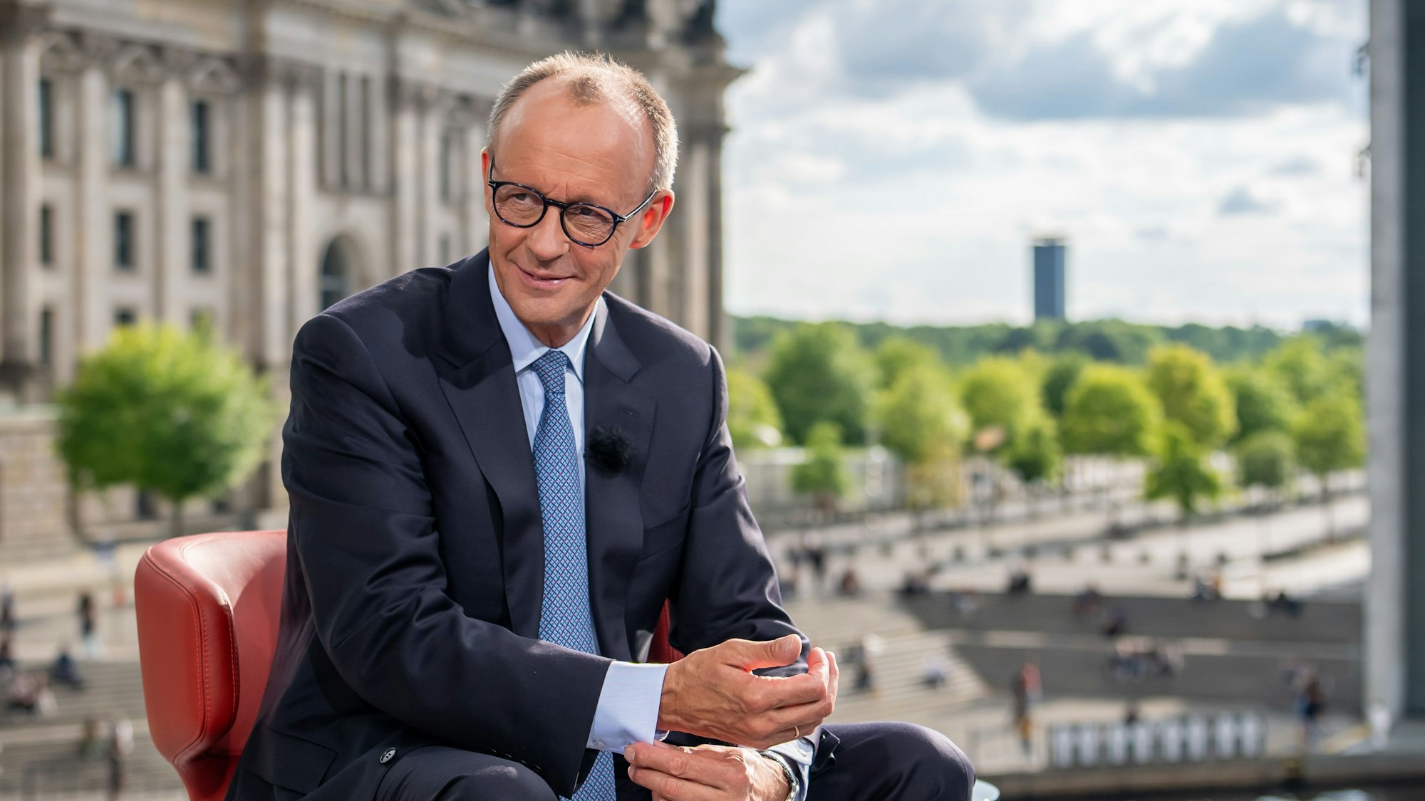 Bundeskanzler Friedrich Merz (CDU) sitzt nach dem ARD-Sommerinterview vor dem Bundestag.