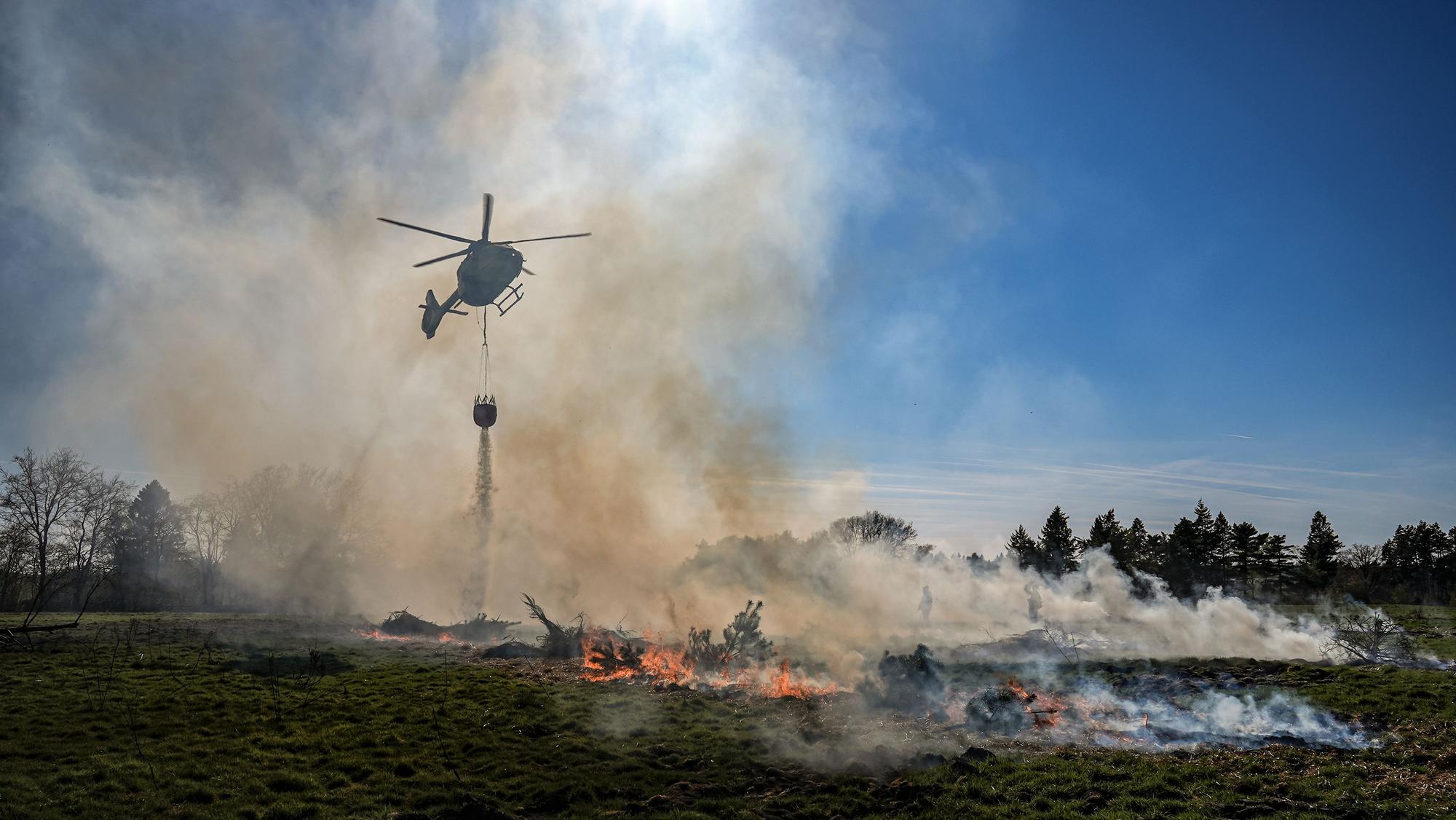 Ein Hubschrauber der NRW-Polizei im Löscheinsatz.