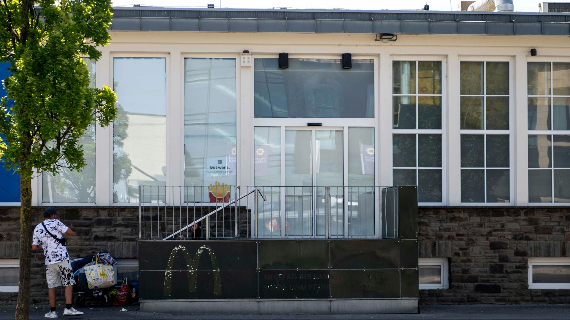 Die McDonald's-Filiale am Euskirchener Bahnhof ist geschlossen. Ein Mann steht vor dem Gebäude, an dem die Fensterscheiben abgeklebt wurden.