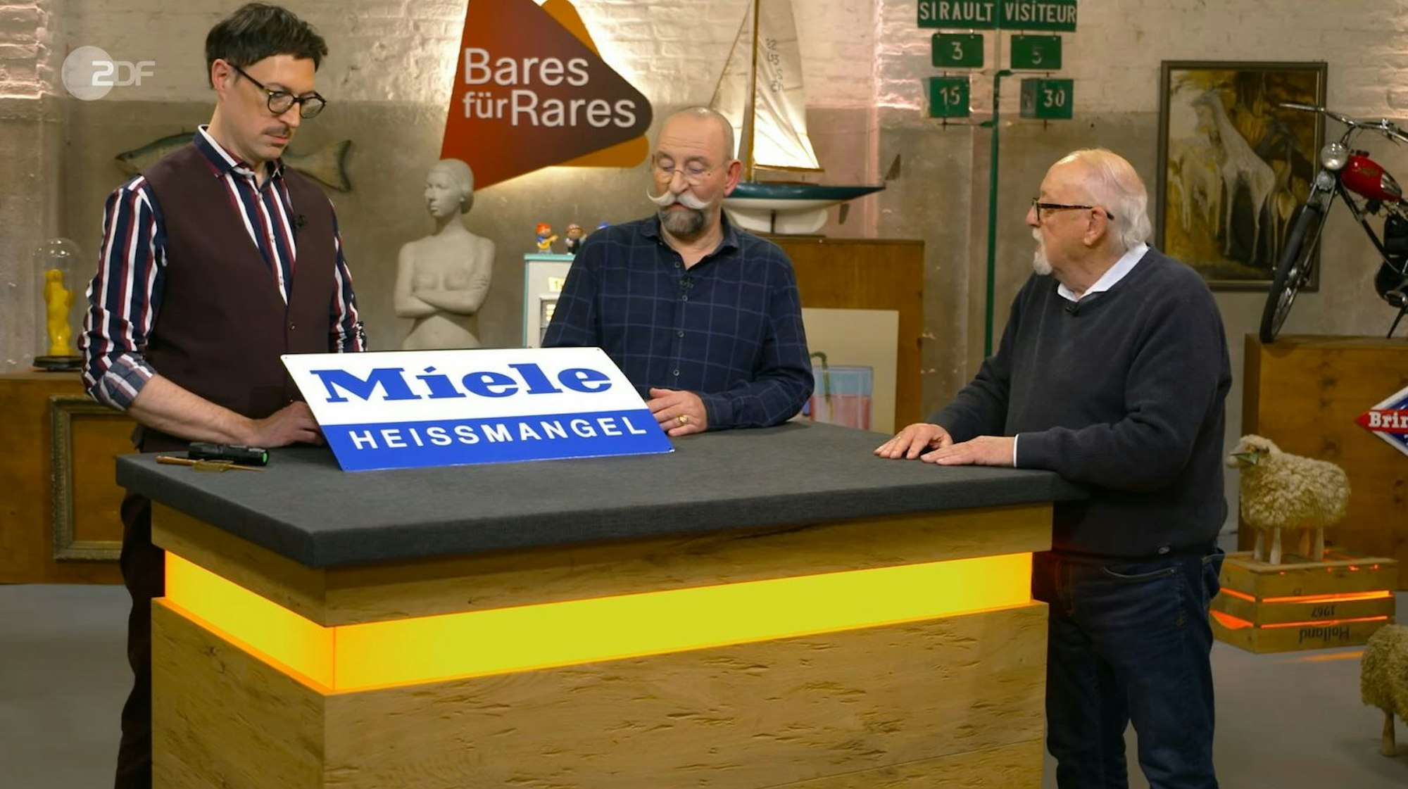 Auch das folgende Objekt bestand aus Blech. Jahrzehntelang hatte das Werbeschild von Miele gut behütet im Keller geschlummert und war nie aufgehängt worden - entsprechend neuwertig sah es aus. Die Schätzung lag bei 200 bis 250 Euro. (Bild: ZDF)