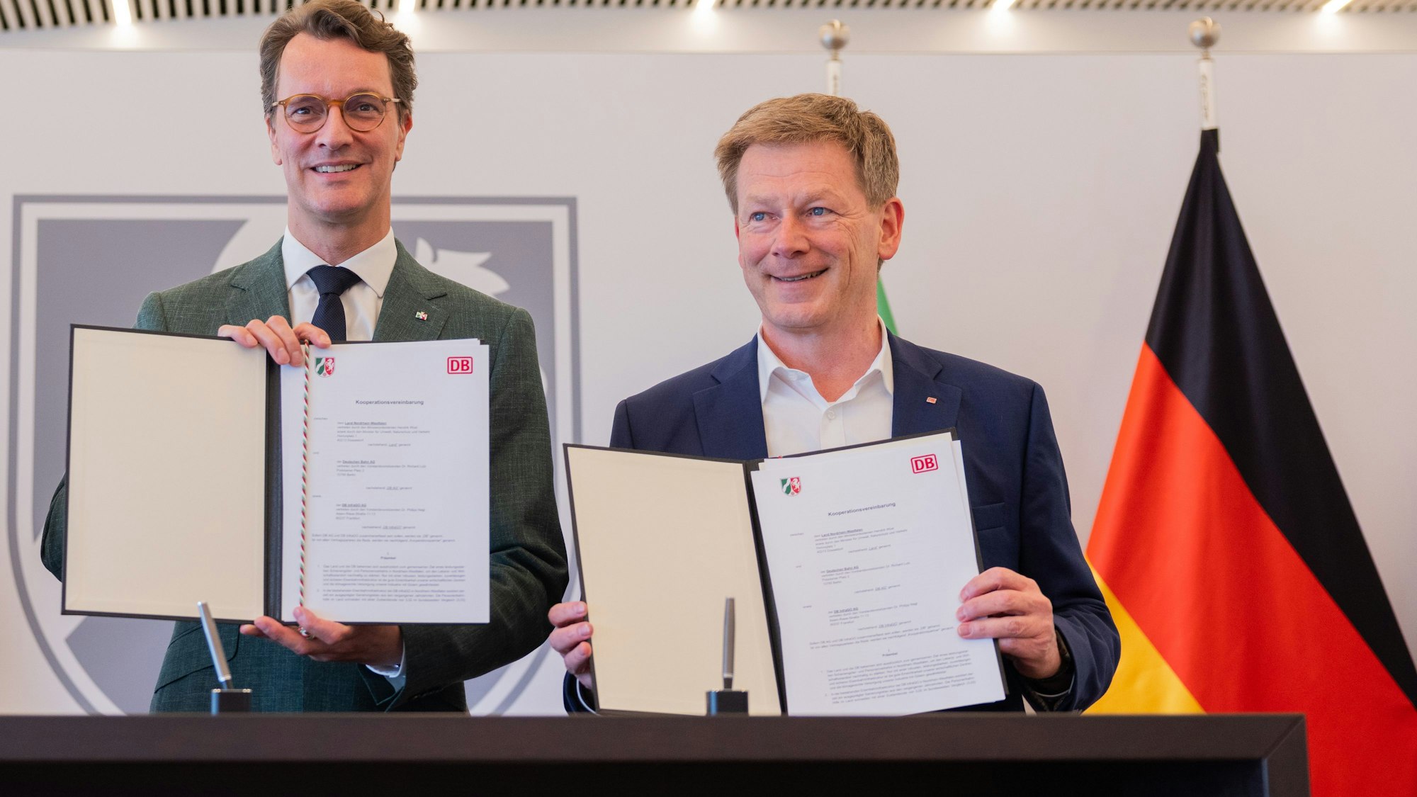 15.07.2025, Nordrhein-Westfalen, Düsseldorf: Hendrik Wüst (l, CDU), Ministerpräsident von Nordrhein-Westfalen, und Richard Lutz, Vorstandsvorsitzender der Deutschen Bahn AG, stehen zusammen bei der Unterzeichnung einer Kooperationsvereinbarung in der Staatskanzlei. Die Landesregierung und die Deutsche Bahn planen, für eine nachhaltige Verbesserung der Eisenbahninfrastruktur weiter zu kooperieren. Dazu wurde eine entsprechende Vereinbarung unterzeichnet. Foto: Rolf Vennenbernd/dpa +++ dpa-Bildfunk +++