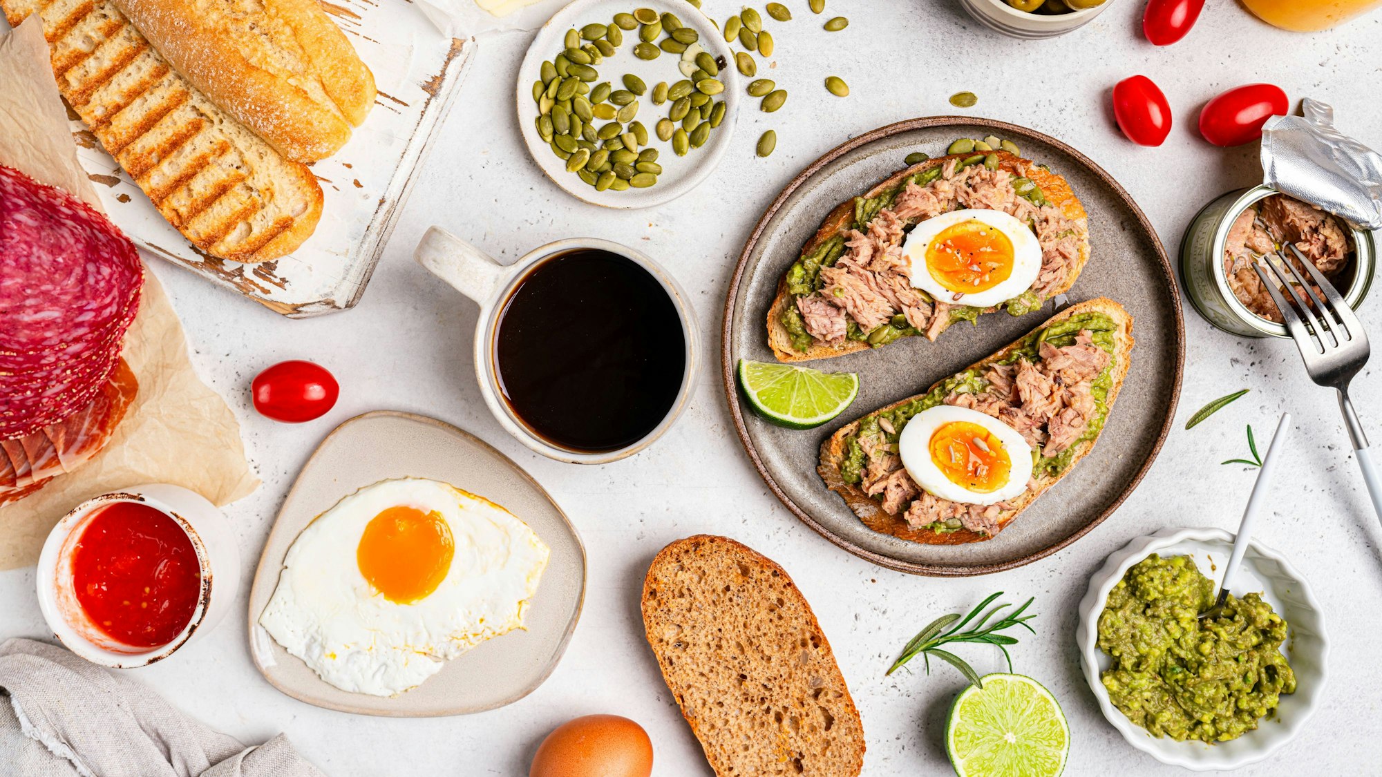 Frühstückstisch mit Zutaten und belegter Stulle.