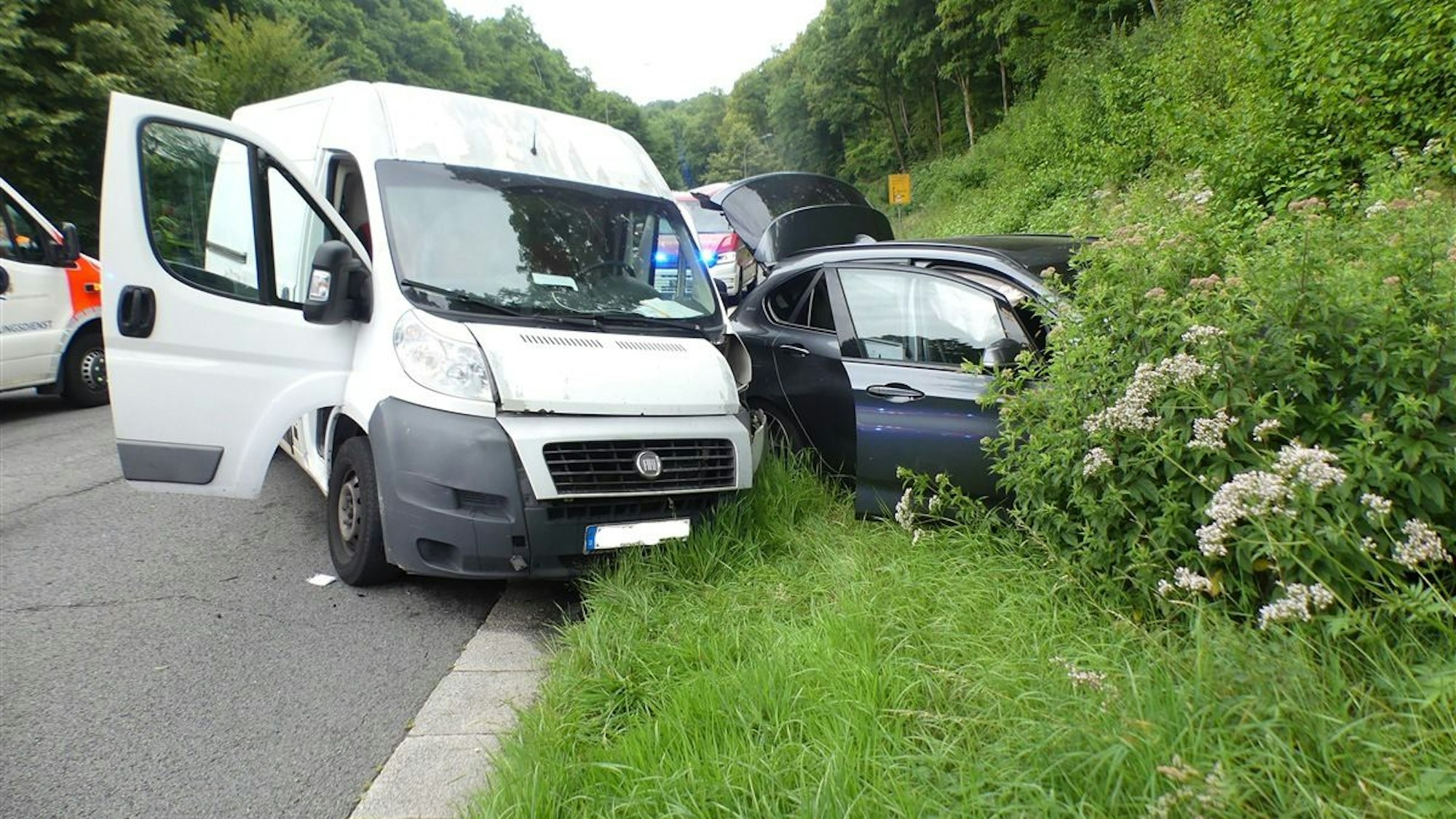 Zwei bei einem Unfall beschädigte Autos stehen auf einer Kreuzung in Reichshof.