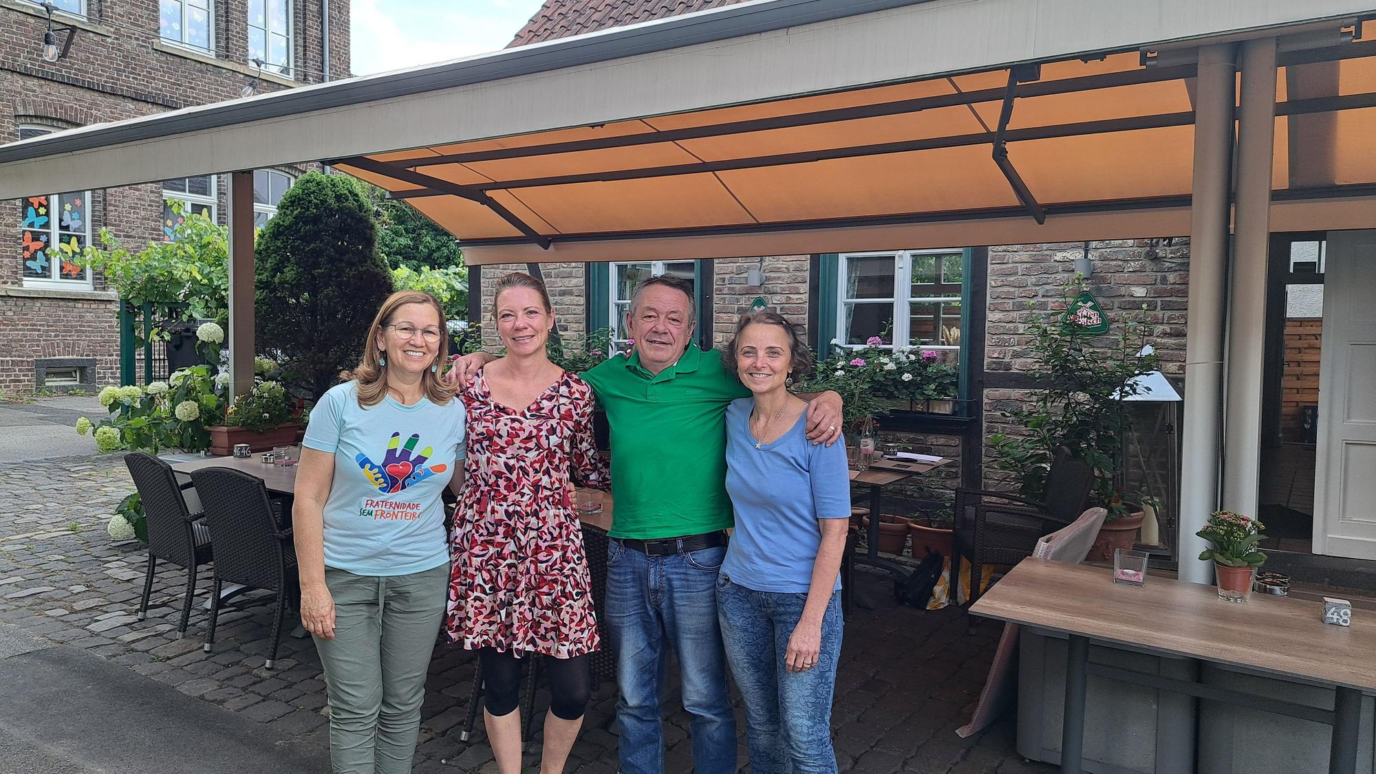 Drei Frauen und ein Mann stehen im Innenhof eines Restaurants.