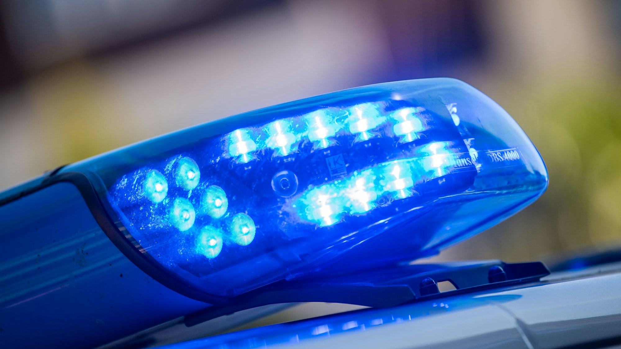 Ein Blaulicht ist auf dem Dach eines Polizeifahrzeugs zu sehen.