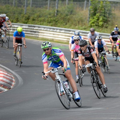 Zahlreiche Radfahrer fahren bei einem Rennen über den Nürburgring.
