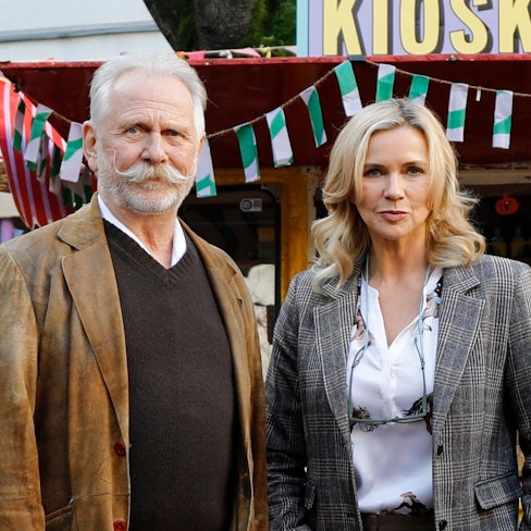 Ein Mann mit Schnäuzer steht neben einer Frau.