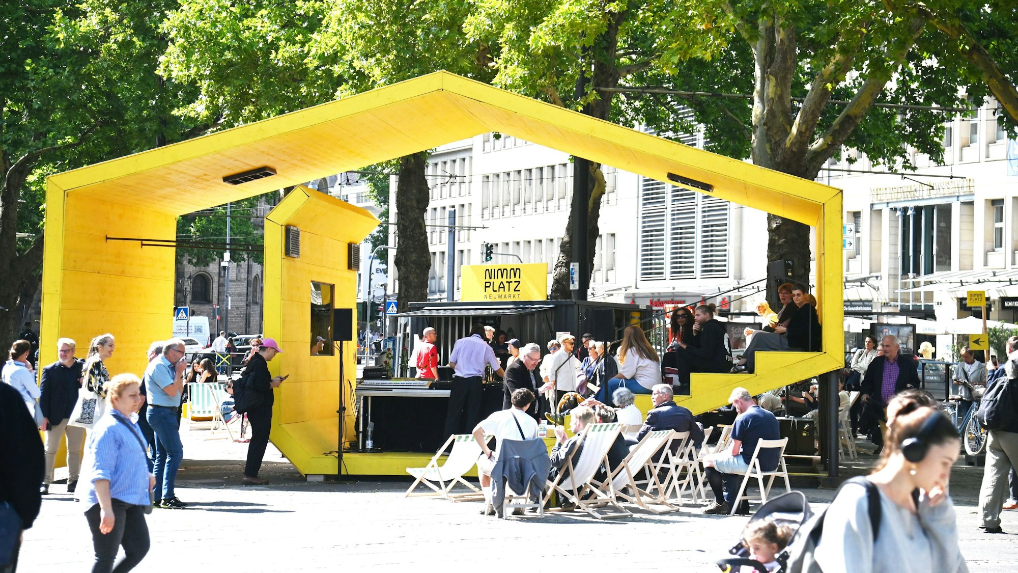 Im gelben Kulturpavillon mitten auf dem Kölner Neumarkt finden im Sommer acht Wochen lang tägliche Kunst- und Kulturveranstaltungen statt. Der Eintritt ist frei.