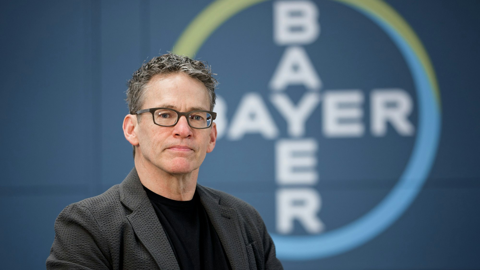 ARCHIV - 10.12.2024, Nordrhein-Westfalen, Leverkusen: Bill Anderson, Vorstandsvorsitzender der Bayer AG, sitzt bei einem Fototermin in der Zentrale des Unternehmens. (zu dpa: «Bayer-Chef bekommt Vertrag verlängert») Foto: Henning Kaiser/dpa +++ dpa-Bildfunk +++