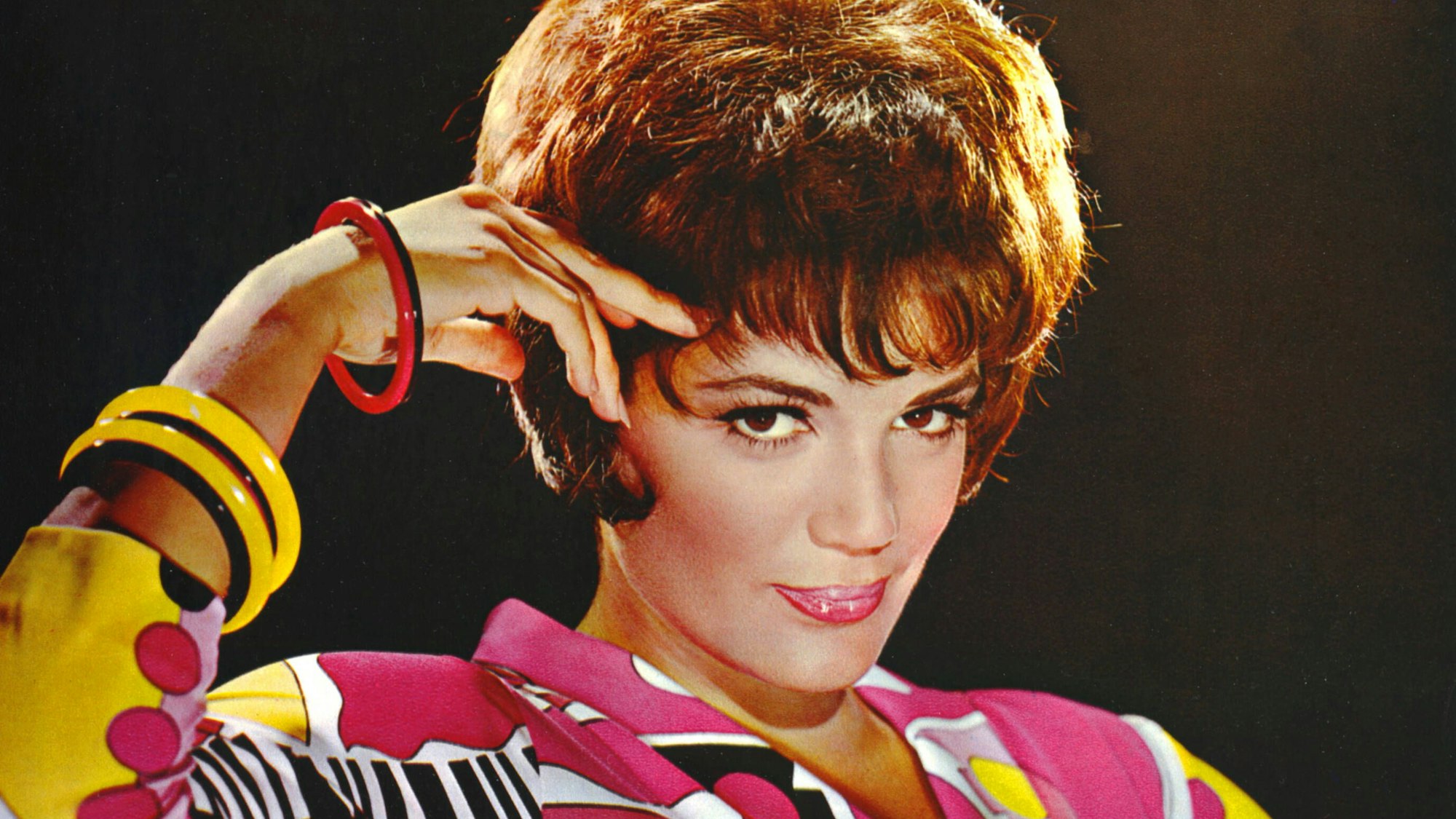 Connie Francis schaut mit gesenktem Kopf in die Kamera, eine Hand an der Schläfe.