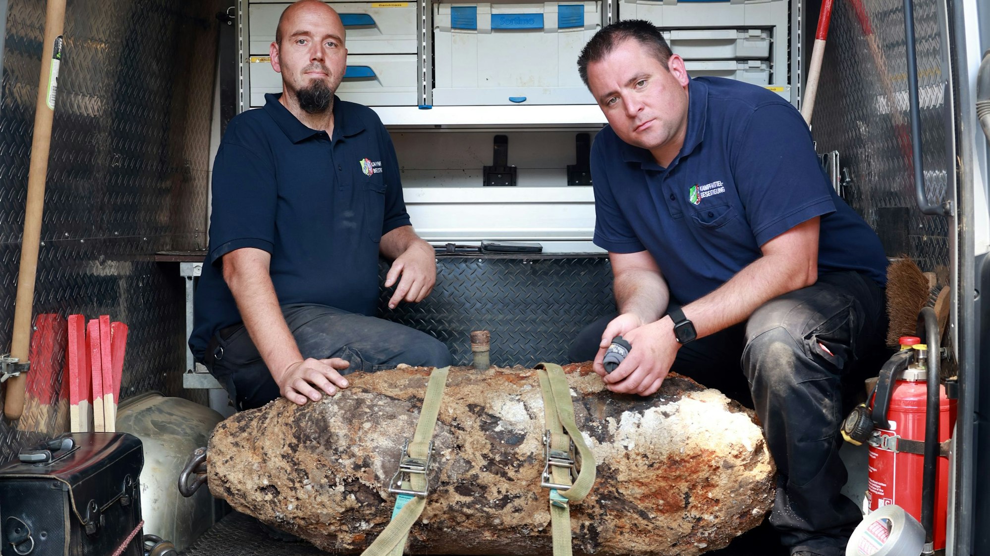 17.07.2025, Köln: Unweit der Universitätsklinik Köln, am Lindenhof, wurde eine 250kg schwere Bombe aus dem Zweiten Weltkrieg gefunden.
Die entschärfte Bombe mit v.l.n.r. Markus Schmitz und Martin Bartels vom Kampfmittelräumdienst.
Foto: Michael Bause