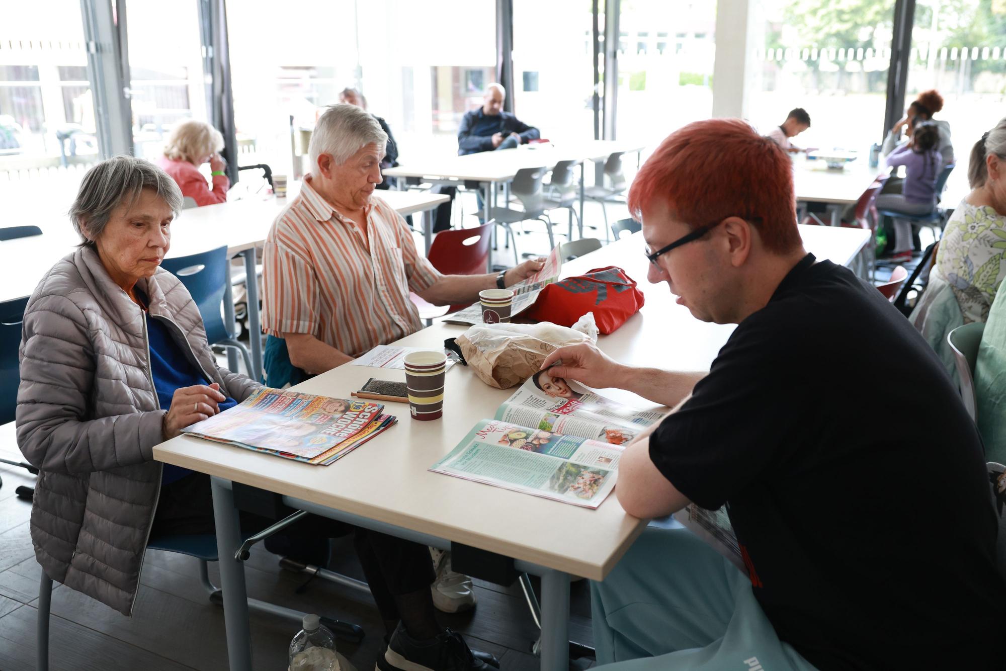 Menschen lesen in Zeitschriften.