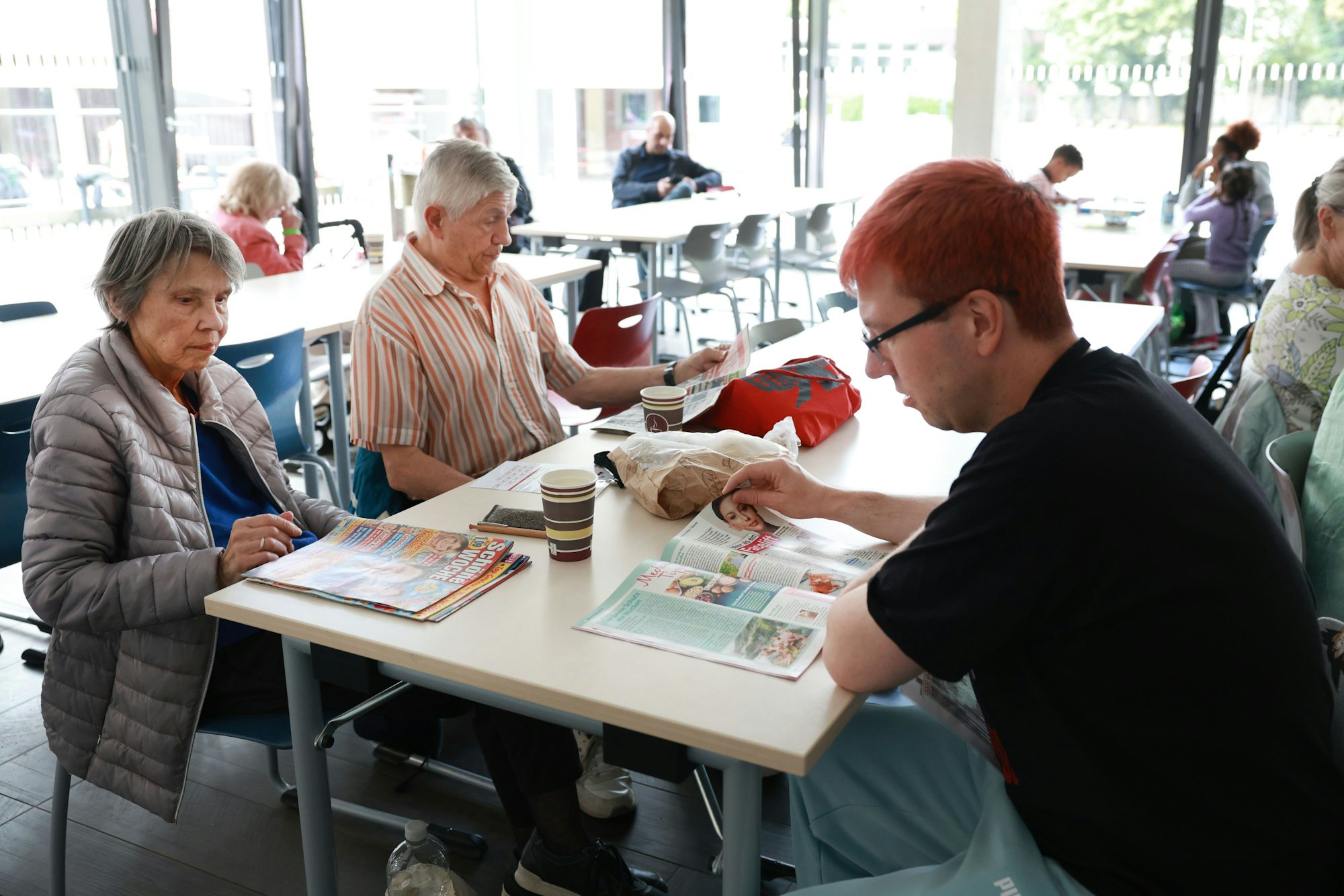 Menschen lesen in Zeitschriften.