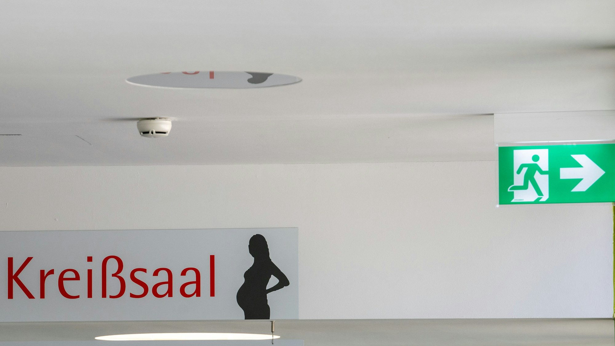 ARCHIV - 19.05.2022, Baden-Württemberg, Ulm: In der Klinik für Frauenheilkunde und Geburtshilfe des Universitätsklinikums weist ein Schild zum Kreißsaal und direkt gegenüber ein Schild den Fluchtweg. (zu dpa: «Weniger Geburten und Hochzeiten in Berlin und Brandenburg») Foto: Stefan Puchner/dpa +++ dpa-Bildfunk +++