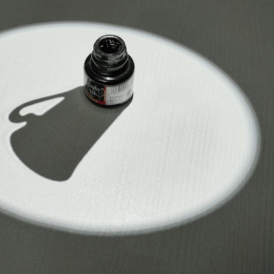 Ein Tintenfass wirft den Schatten einer Kaffeetasse.