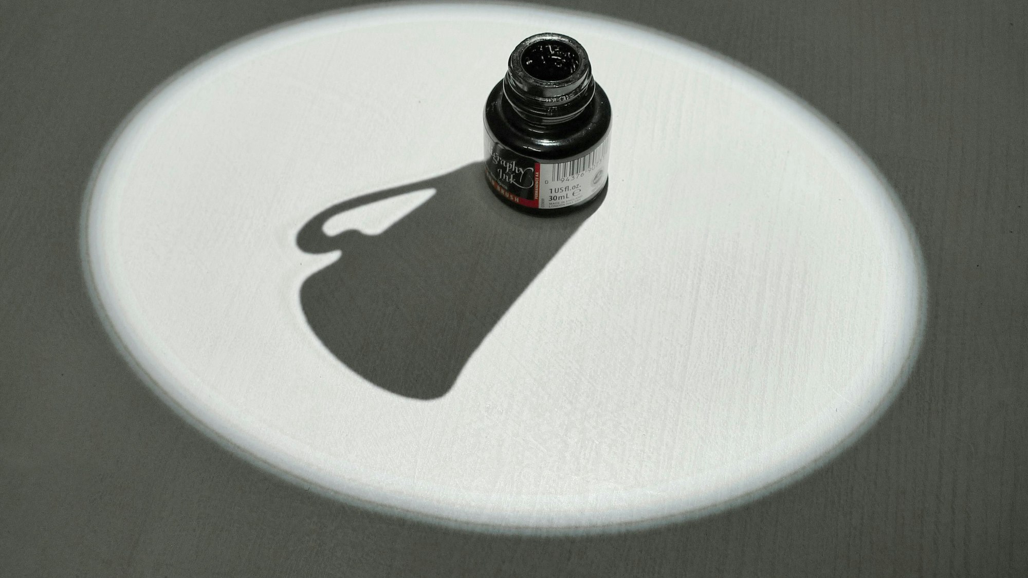 Ein Tintenfass wirft den Schatten einer Kaffeetasse.