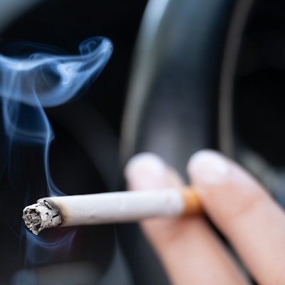 Eine Frau hält eine Zigarette.