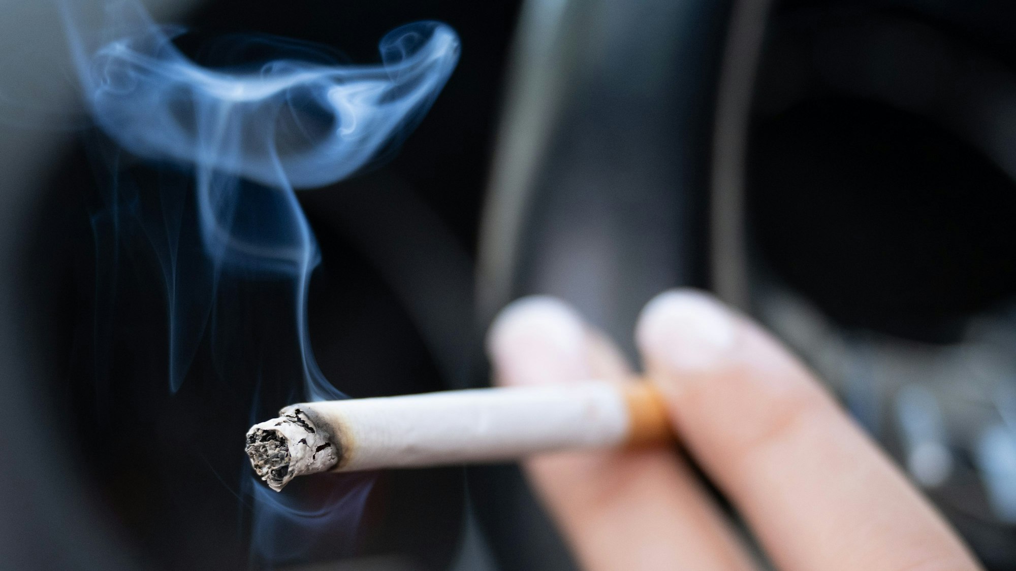 Eine Frau hält eine Zigarette.
