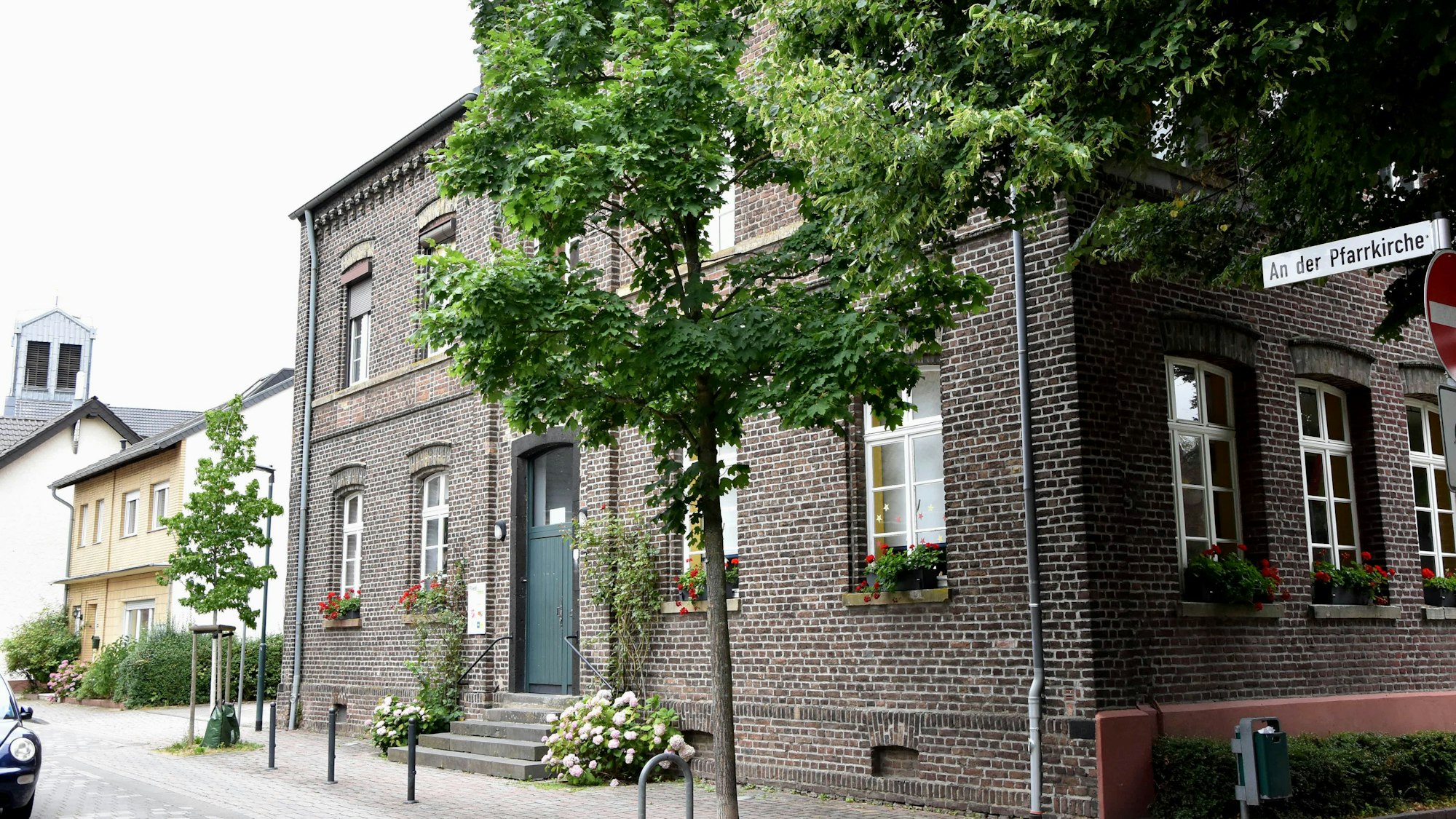 Zu sehen ist ein Backsteinhaus an einer Straße.