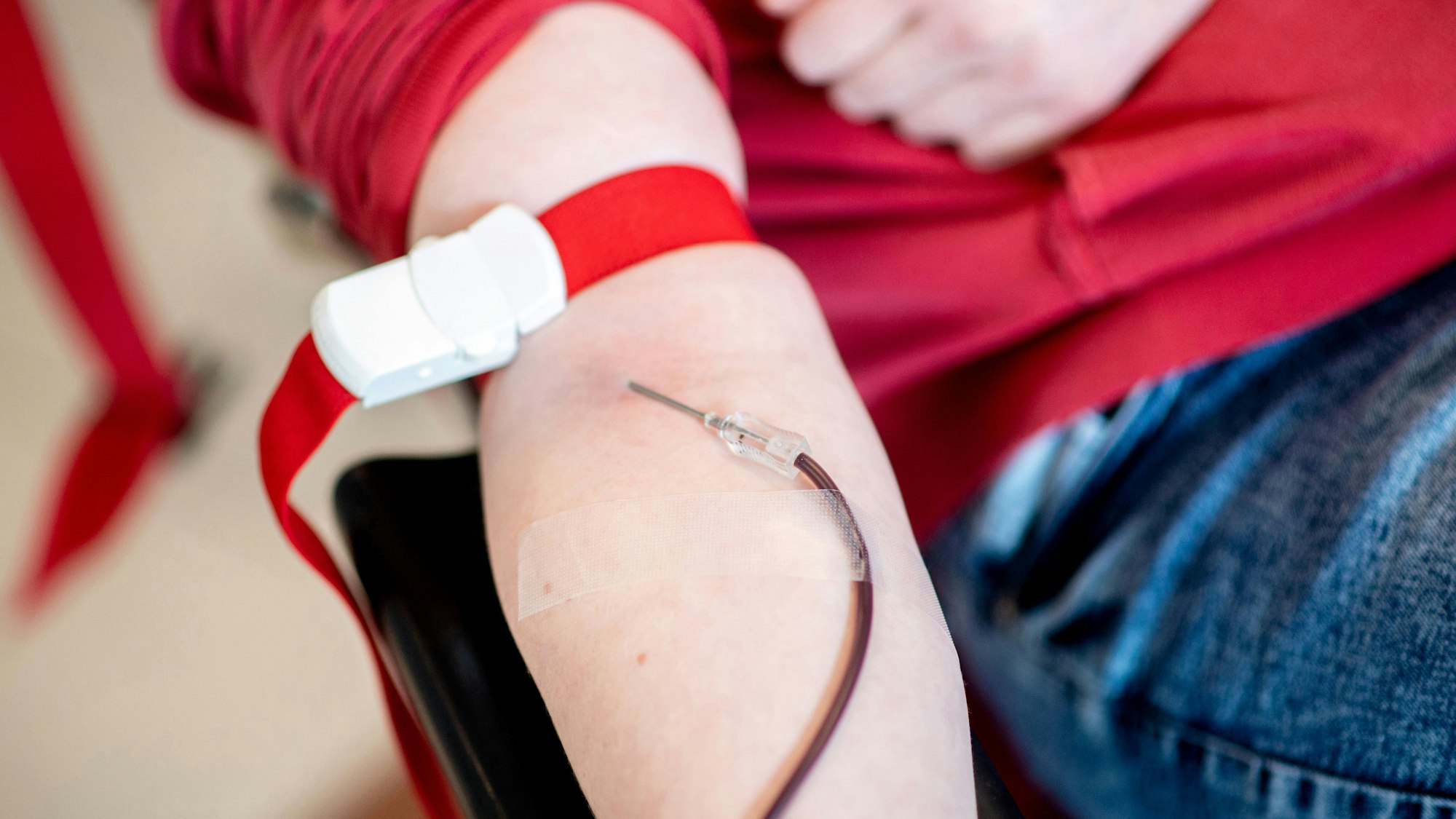 ARCHIV - 06.05.2021, Sachsen-Anhalt, Magdeburg: Blut läuft während einer Blutspende beim Blutspendedienst des Deutschen Roten Kreuzes (DRK) vom Arm einer Spenderin durch eine Nadel in einen Beutel. (zu dpa: «Blutspendedienst ehrt seine Super-Spender») Foto: Hauke-Christian Dittrich/dpa +++ dpa-Bildfunk +++