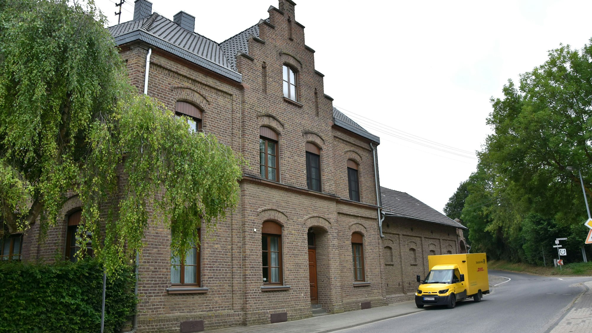 Zu sehen ist ein Backsteingebäude an einer Straße.