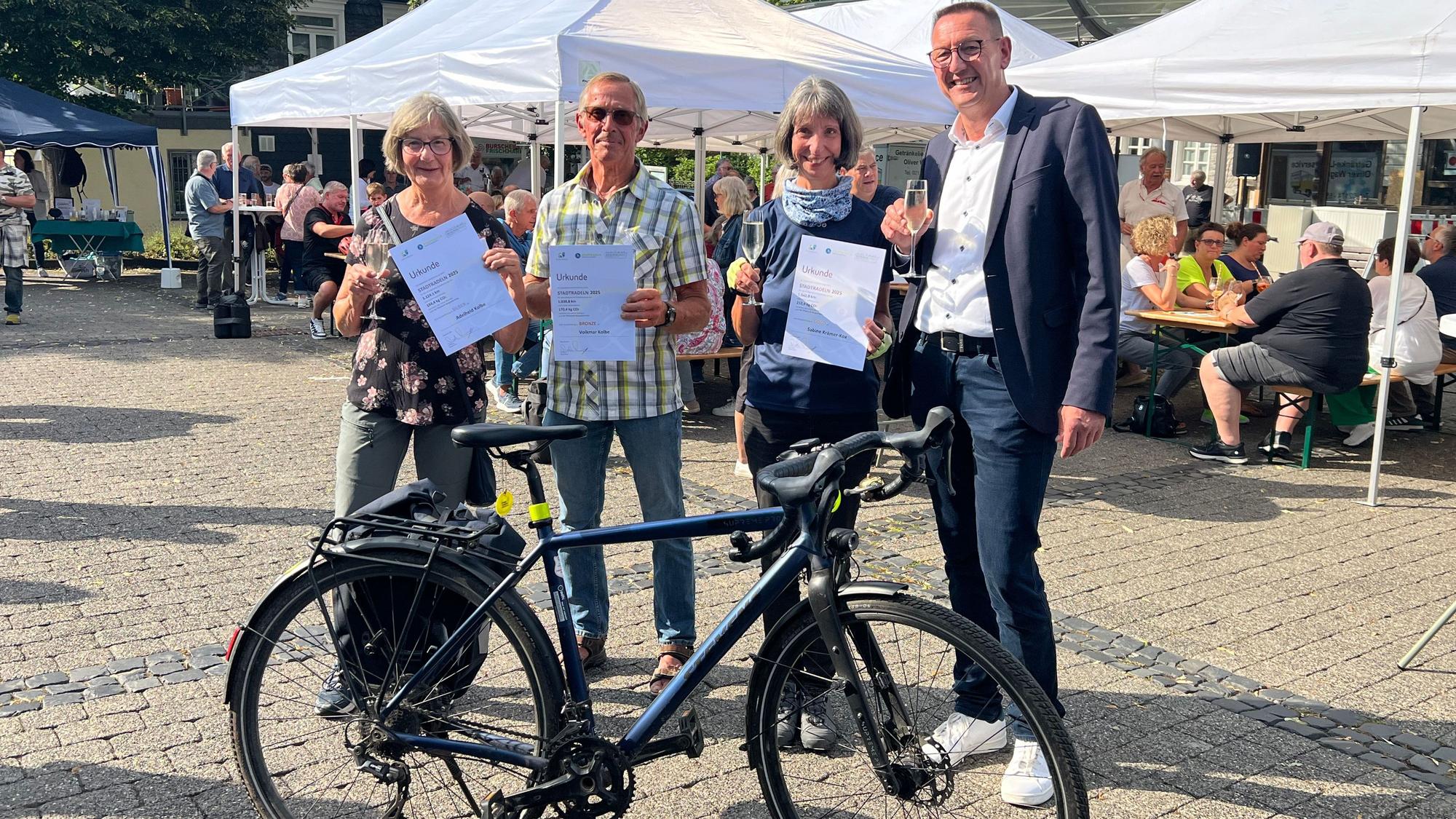 Bürgermeister Dirk Runge (r.) hat Adelheid Kolbe (zweiter Platz, v.l.) Volkmar Kolbe (dritter Platz) Sabine Krämer-Kox (erster Platz) für ihre Kilometer beim Stadtradeln ausgezeichnet.