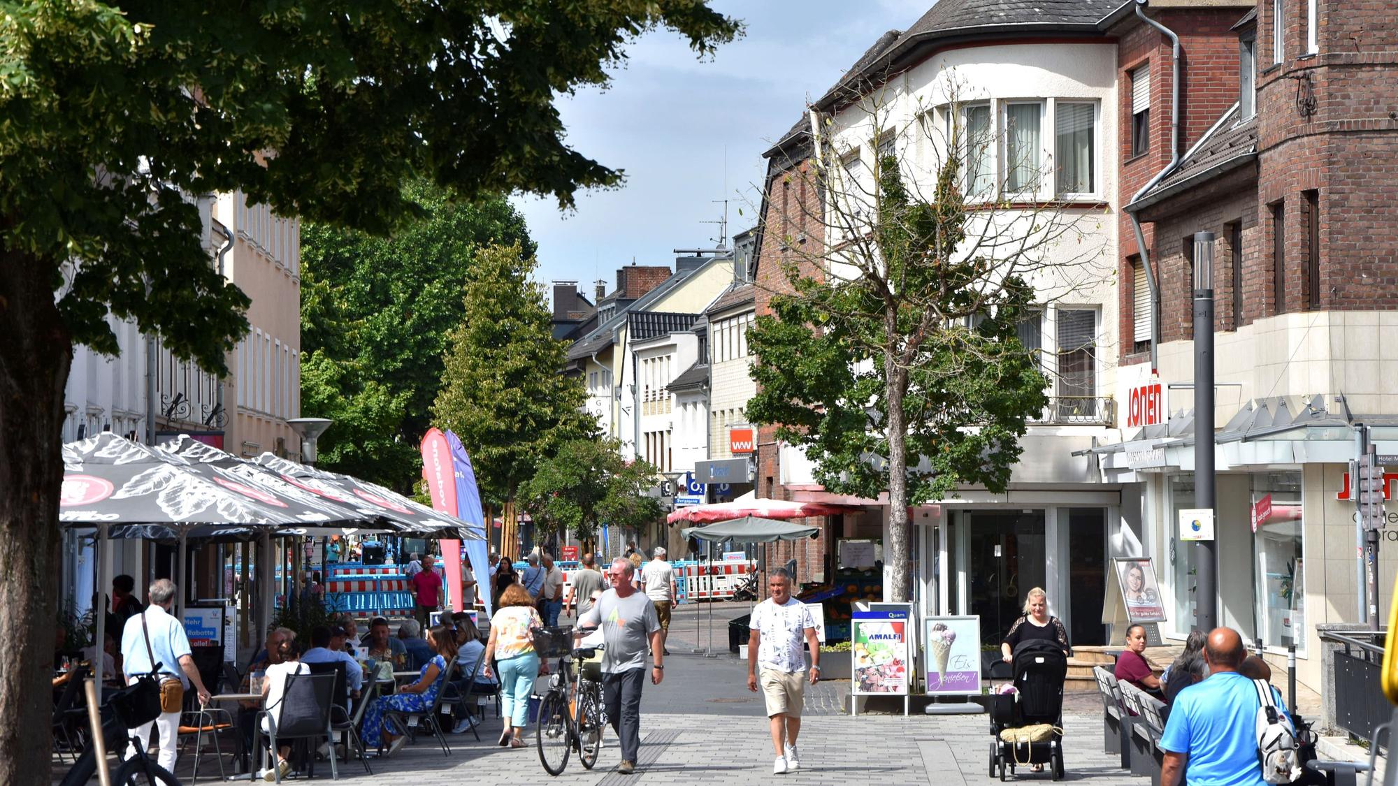 Auf dem Bild ist eine Einkaufsstraße zu sehen.