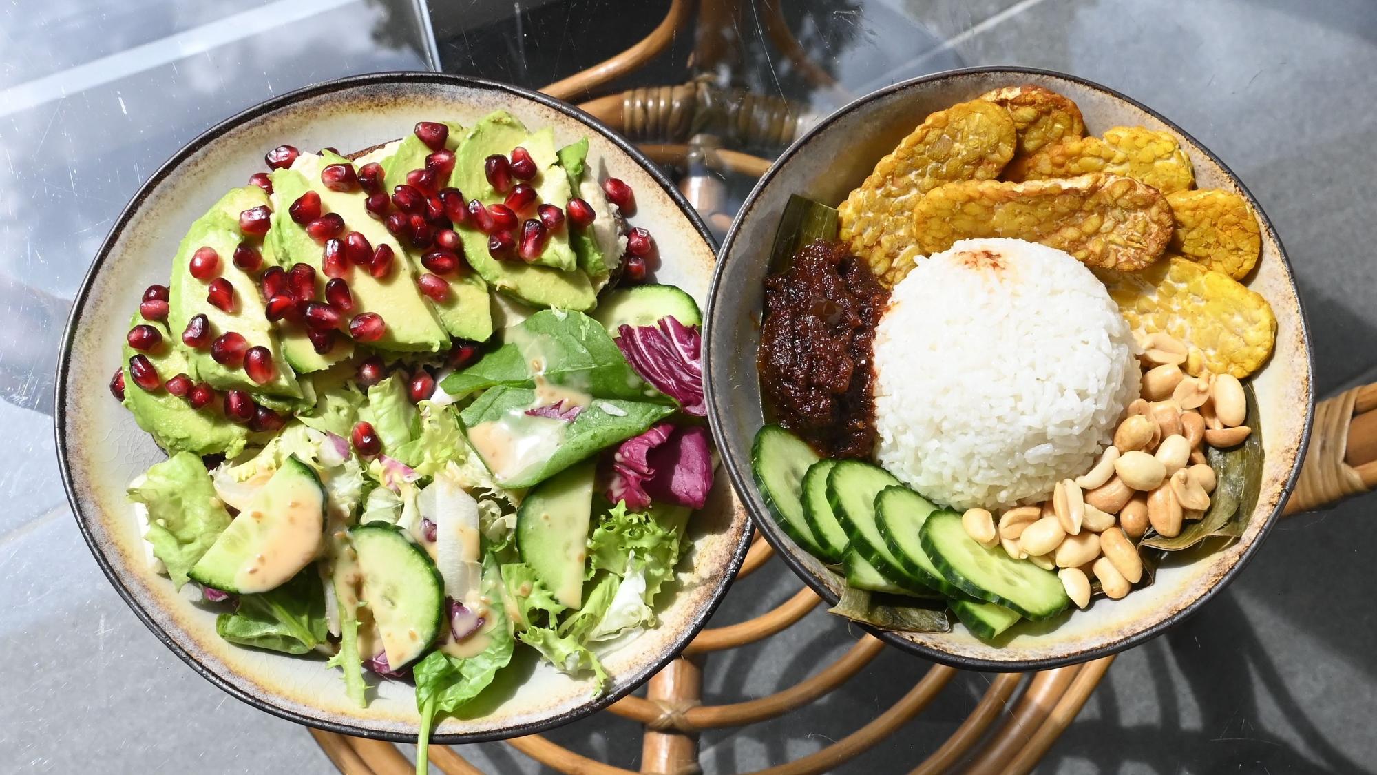 Ein Salat mit Avocado und Granatapfel und eine Reisbowl mit Tempeh, Erdnüssen und Gemüse