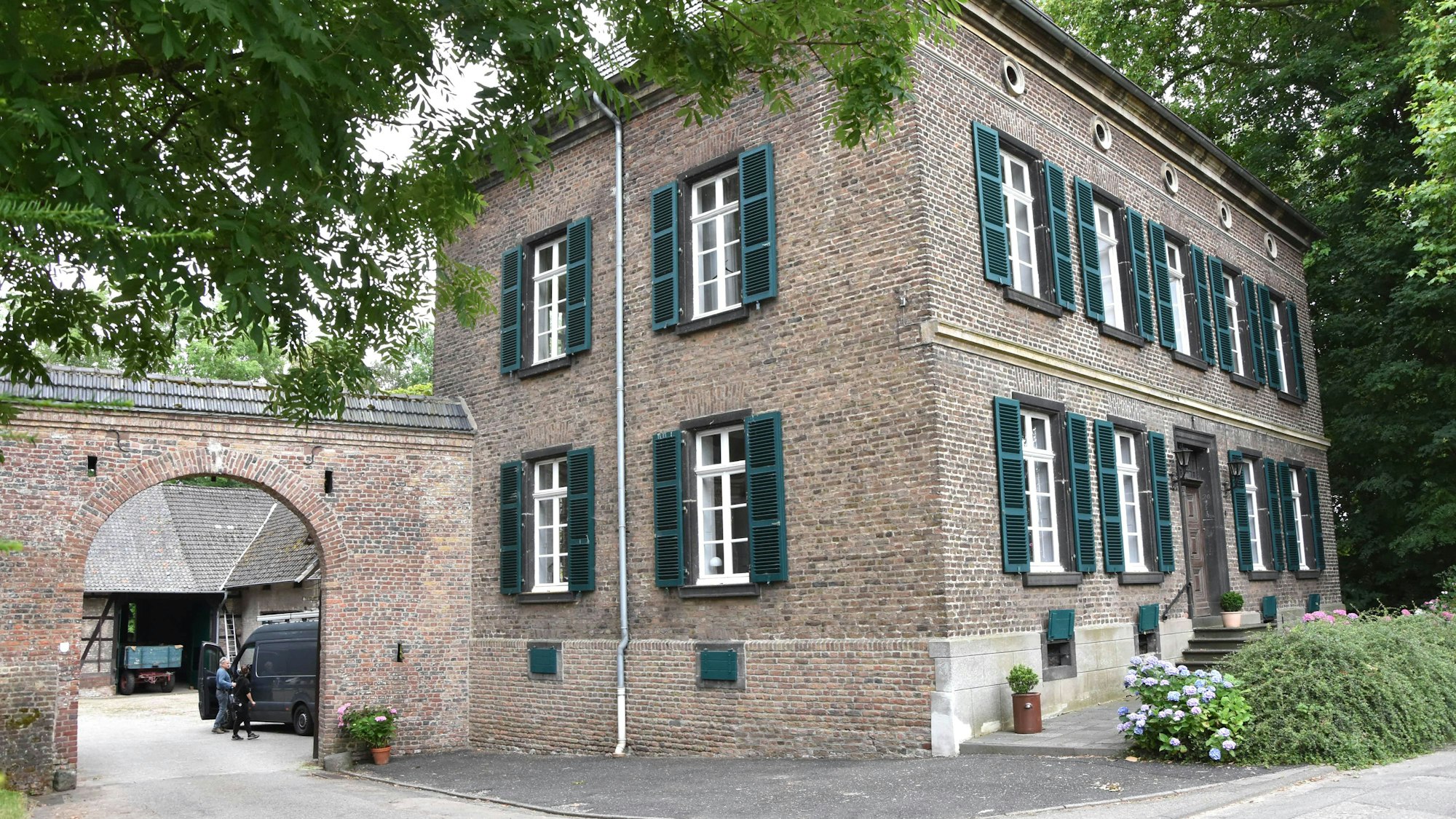 Zu sehen ist ein Backsteinhaus an einer Straße.