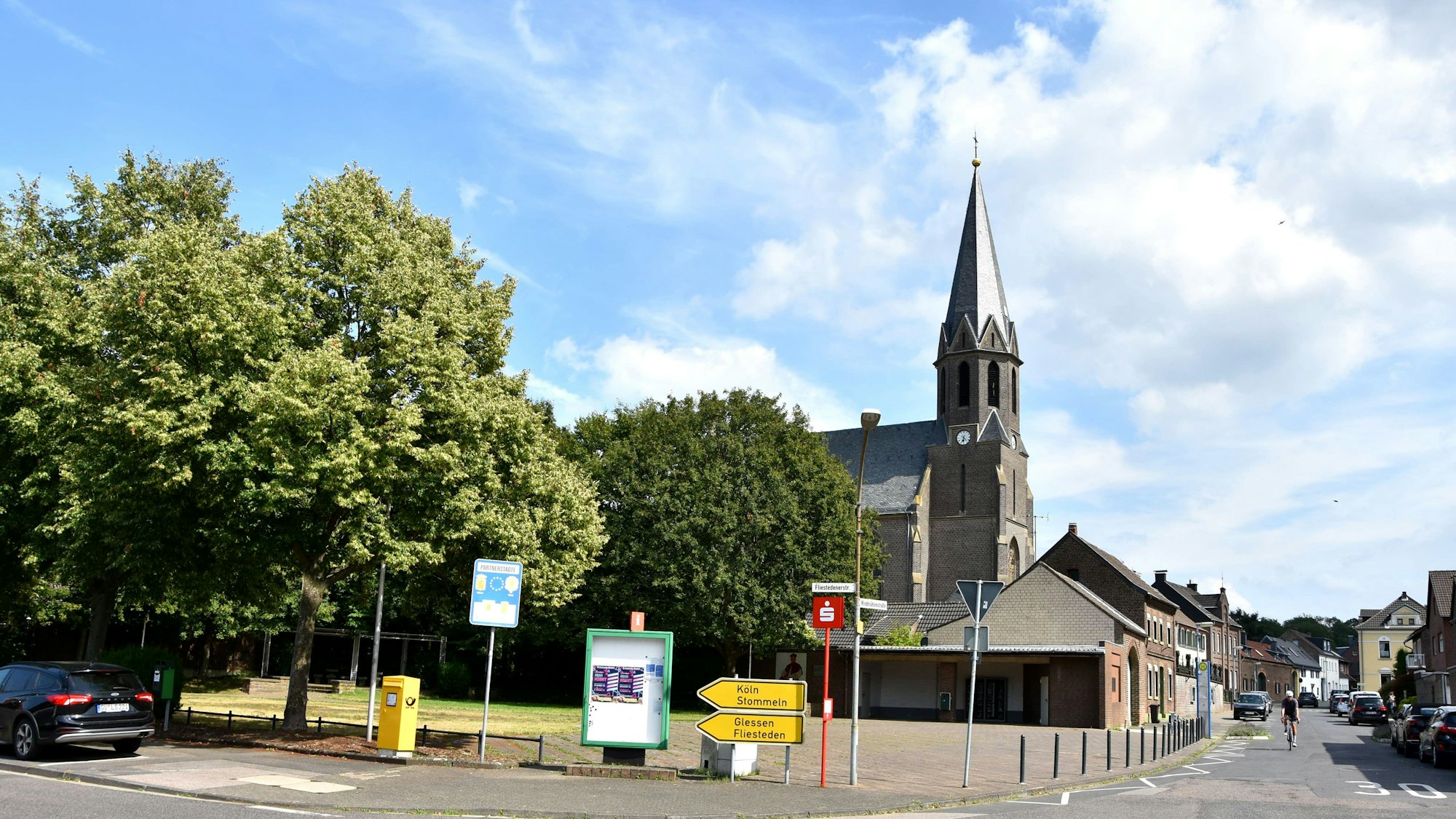 Zu sehen ist eine Kirche an einer Straße.