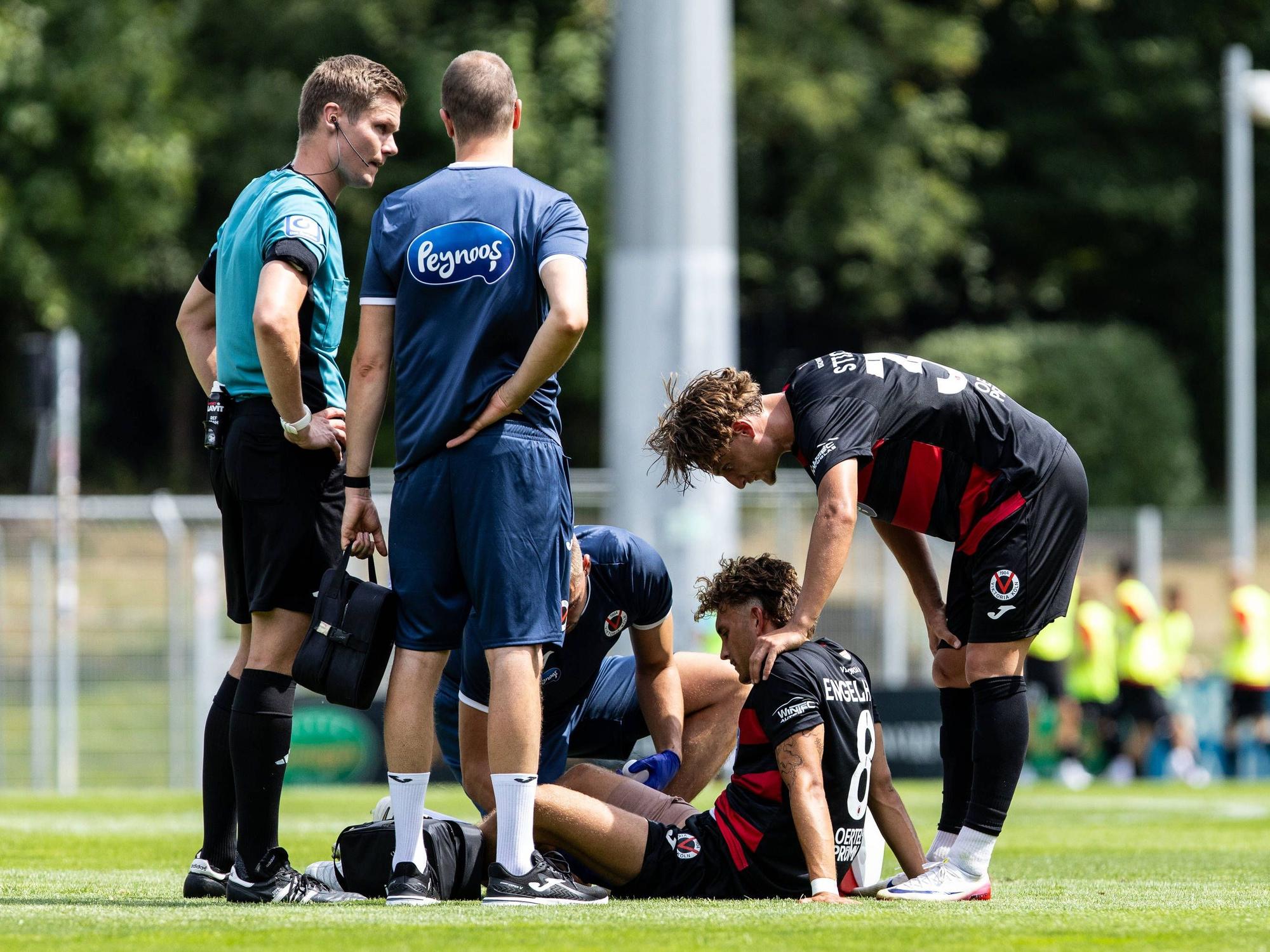 Testspiel: FC Viktoria Köln - VVV-Venlo 19.07.2025 Florian Engelhardt FC Viktoria Köln, 8 sitzt auf dem Rasen nach der Verletzung, der Spieler Johan Sticker FC Viktoria Köln, 33 steht daneben. Testspiel: FC Viktoria Köln - VVV-Venlo Sportpark Höhenberg, Köln 19.07.2025 *** Test match FC Viktoria Köln VVV Venlo 19 07 2025 Florian Engelhardt FC Viktoria Köln, 8 sits on the pitch after the injury, the player Johan Sticker FC Viktoria Köln, 33 stands next to him Test match FC Viktoria Köln VVV Venlo Sportpark Höhenberg, Cologne 19 07 2025 Copyright: xBEAUTIFULxSPORTS/Buriakovx