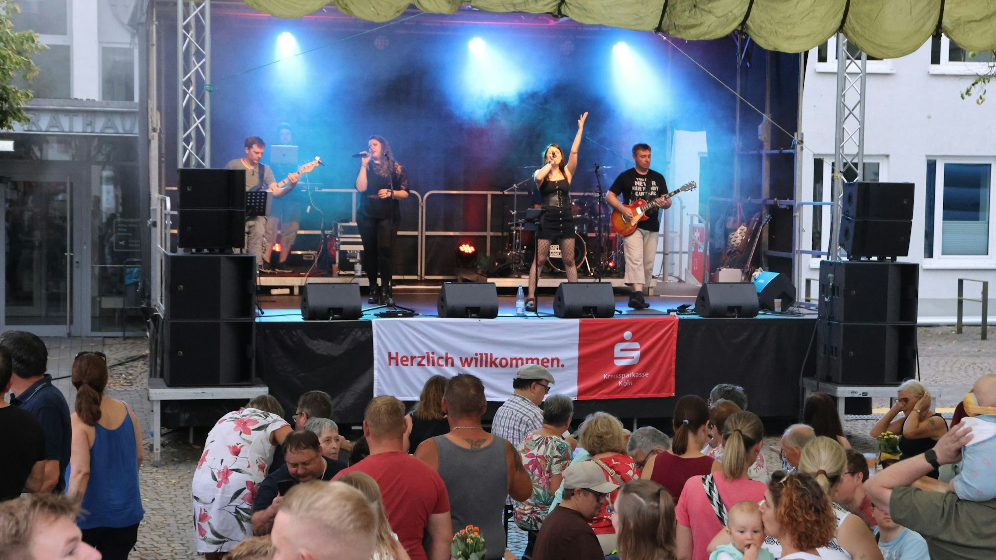 Eine Rockband auf der Bühne vor Publikum.